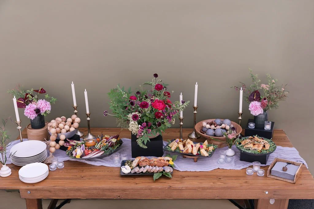 Festive table setup with flowers, candles, and assorted snacks produced by Urban Organics SF.