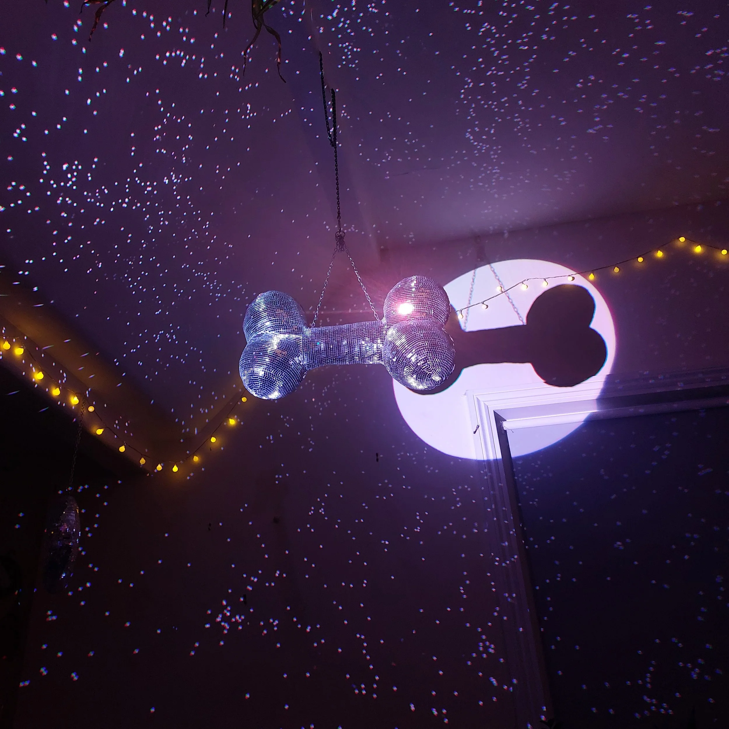 Decorative ceiling with string lights and disco balls, creating a starry effect on the ceiling.