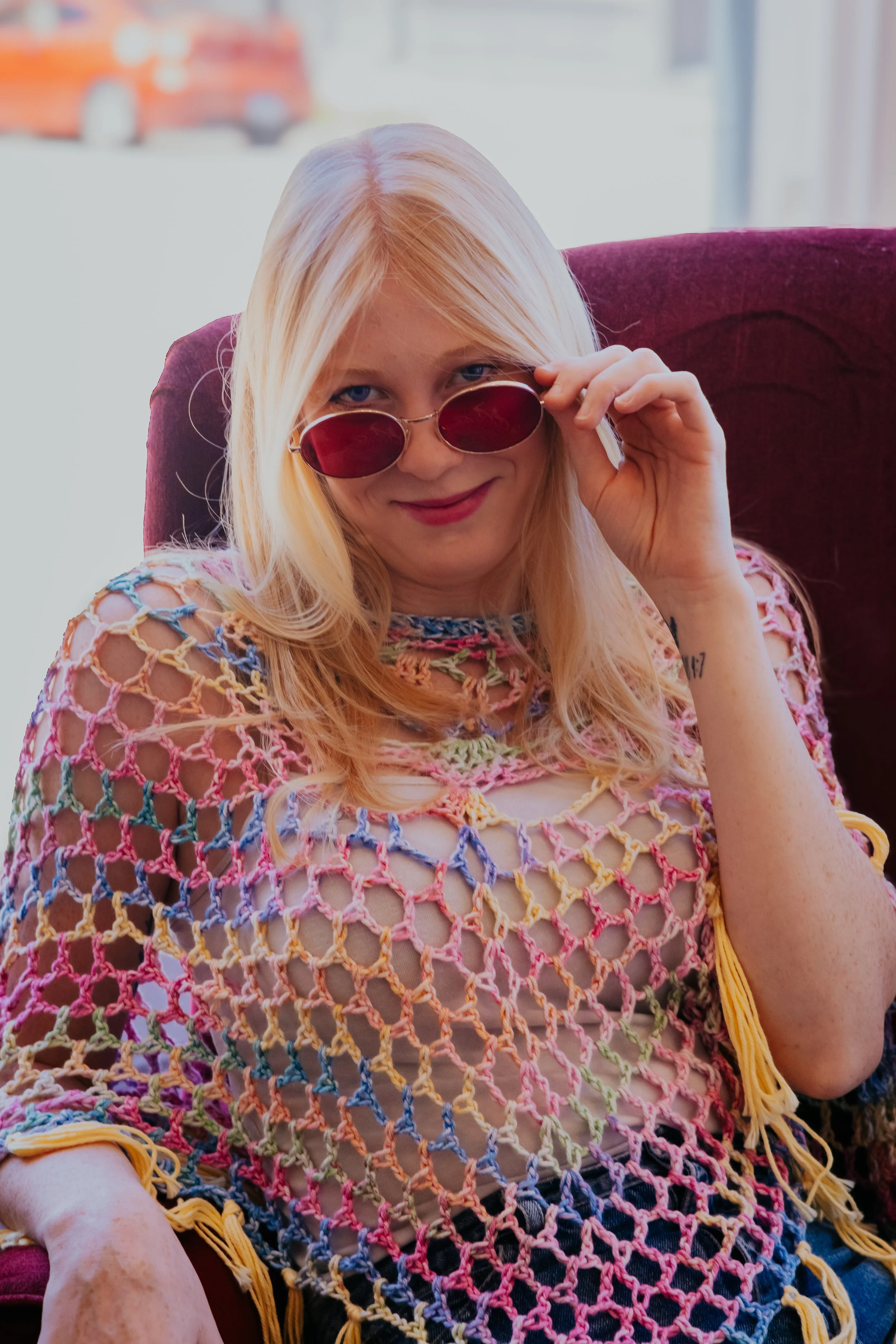 Rainbow crochet poncho with yellow fringe, styled with sunglasses