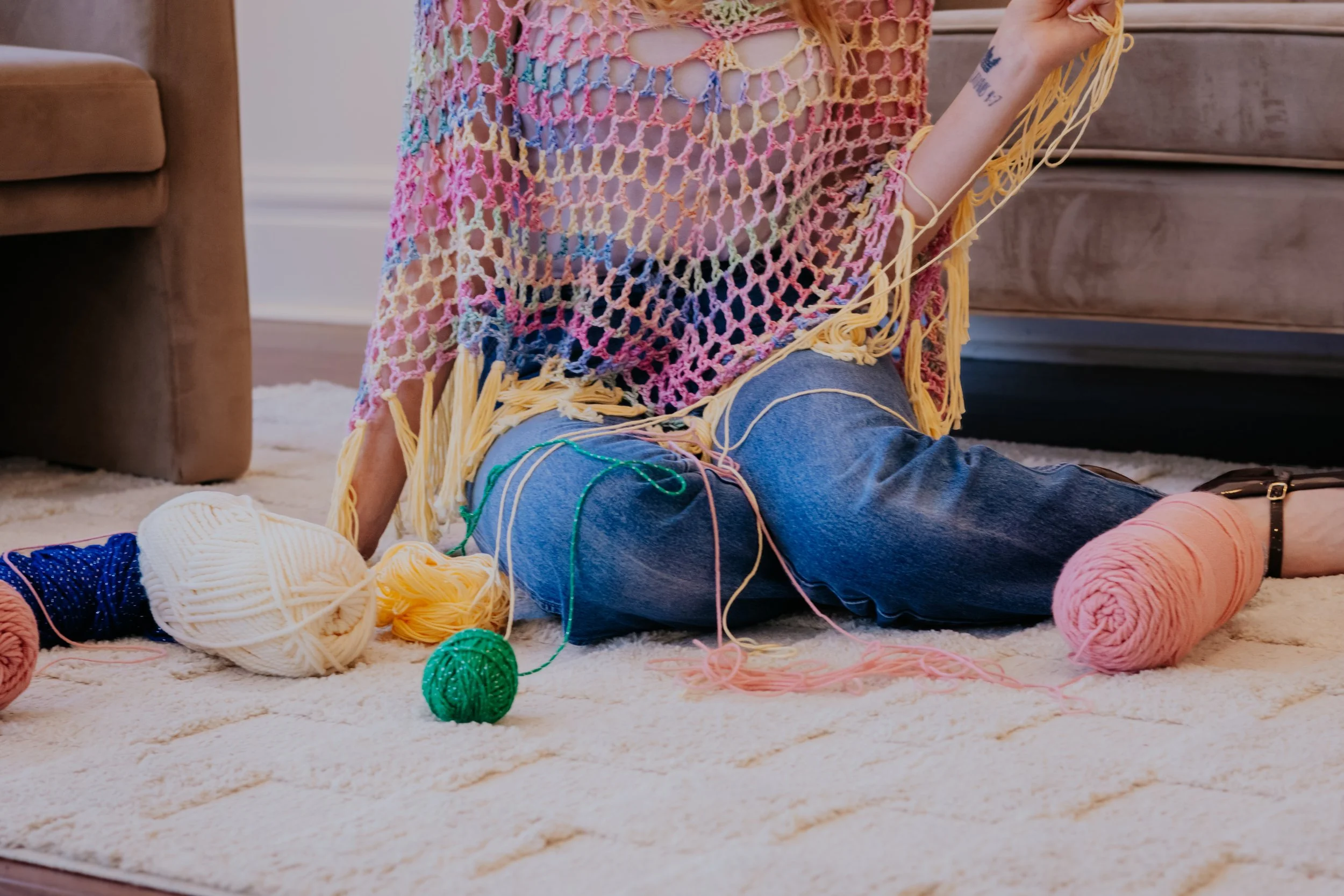 Crocheting a poncho by hand with skeins of yarn