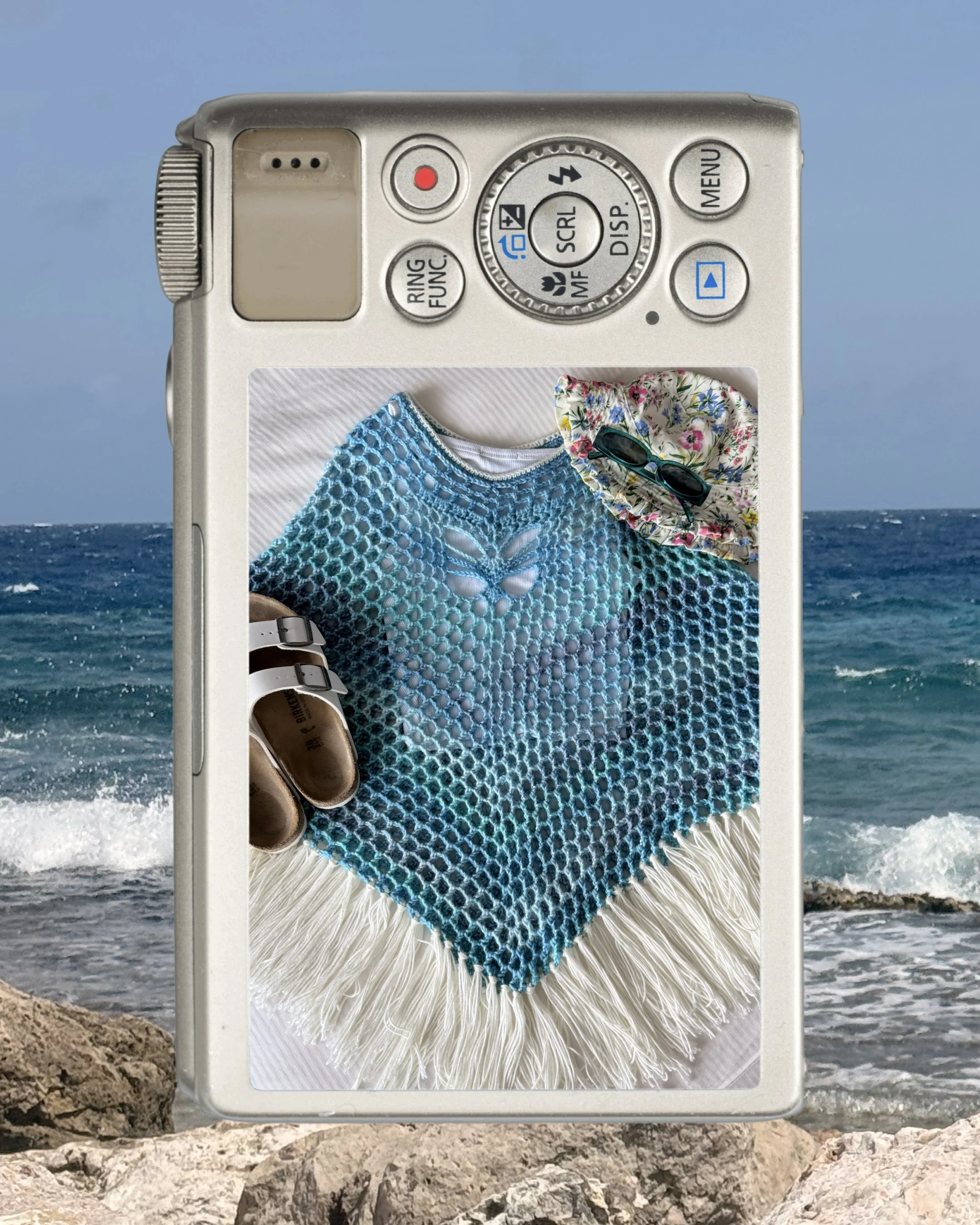 Teal and white crochet poncho with sandals and a floral hat, framed by the ocean