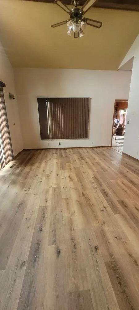Spacious living room with freshly installed light wood luxury vinyl plank flooring