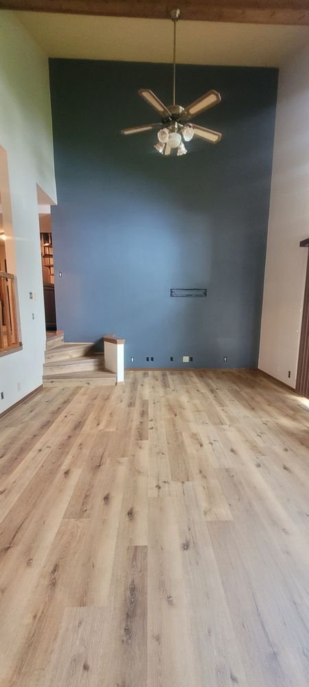 Large empty living room with beautiful light gray-brown luxury vinyl plank flooring