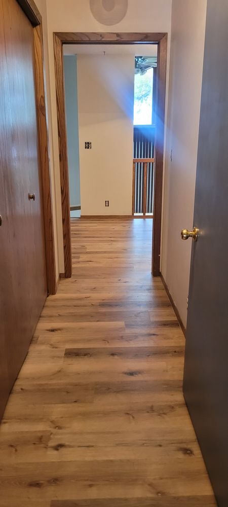 Hallway featuring beautiful light luxury vinyl plank flooring leading to bright living area
