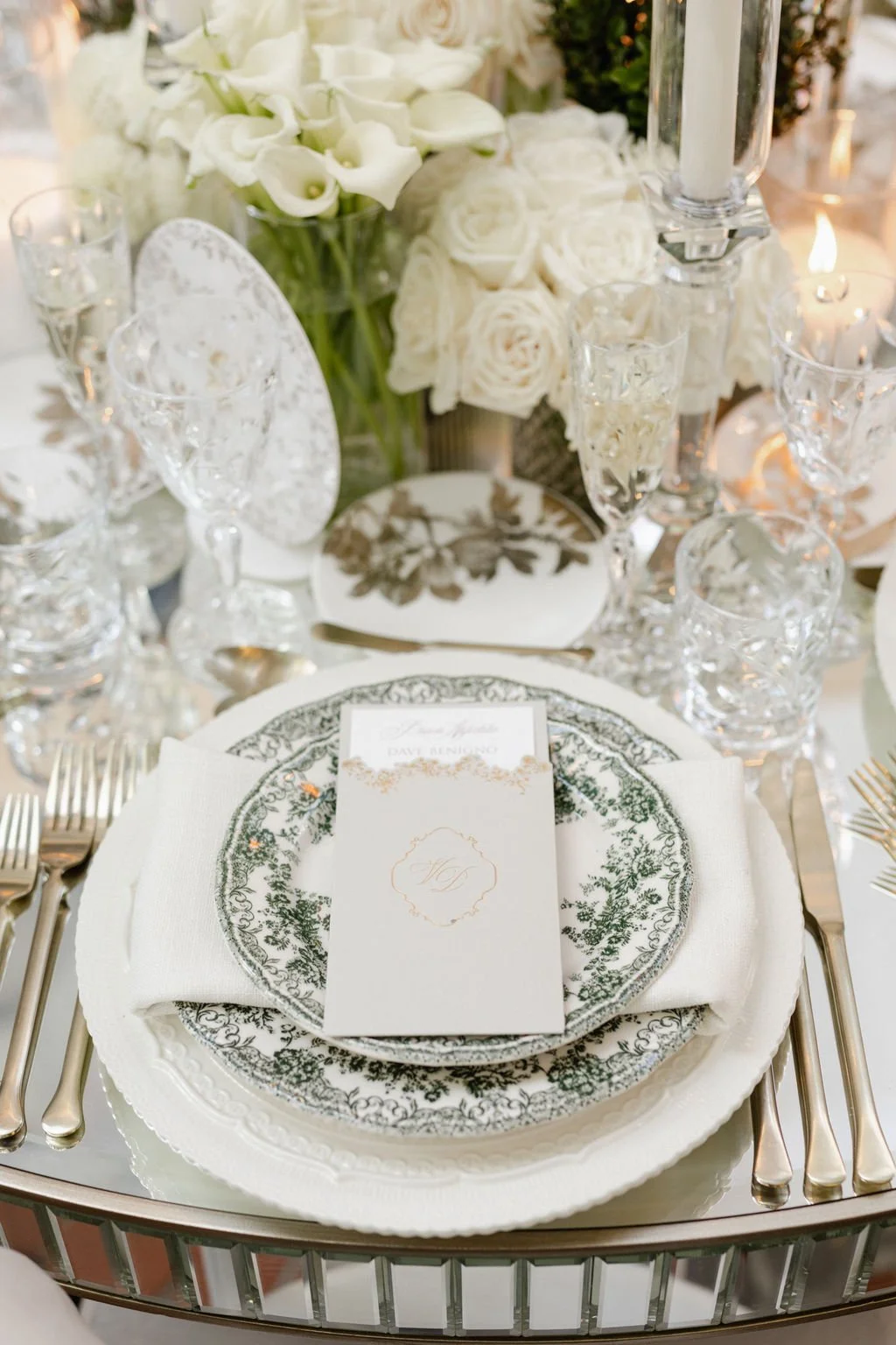 Elegant table setting with floral centerpiece, fine china, crystal glasses, and a menu card for a wedding or formal event.