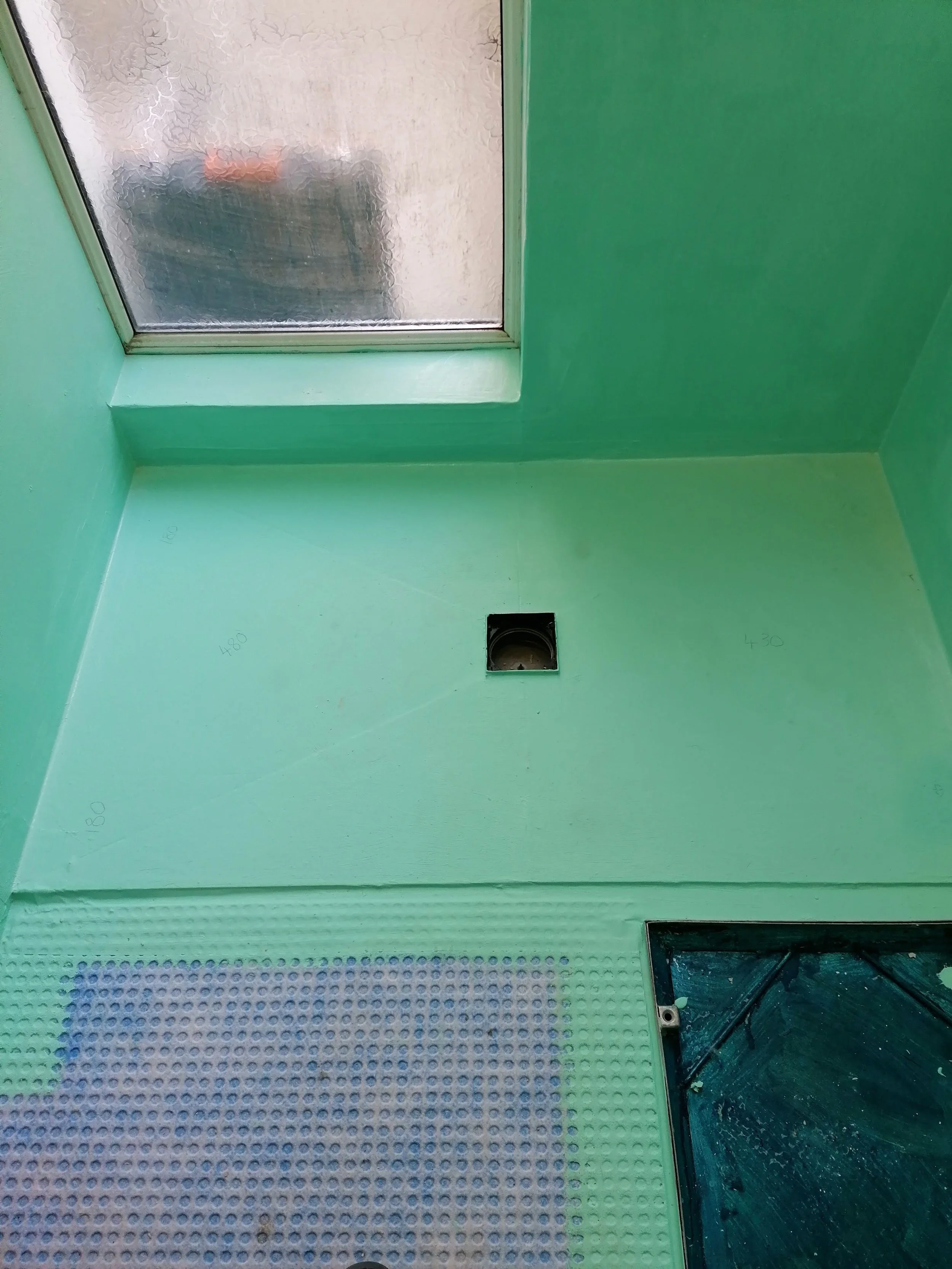 Green walls and ceiling with a skylight window and a vent hole, with part of a black speaker and granite countertop visible.