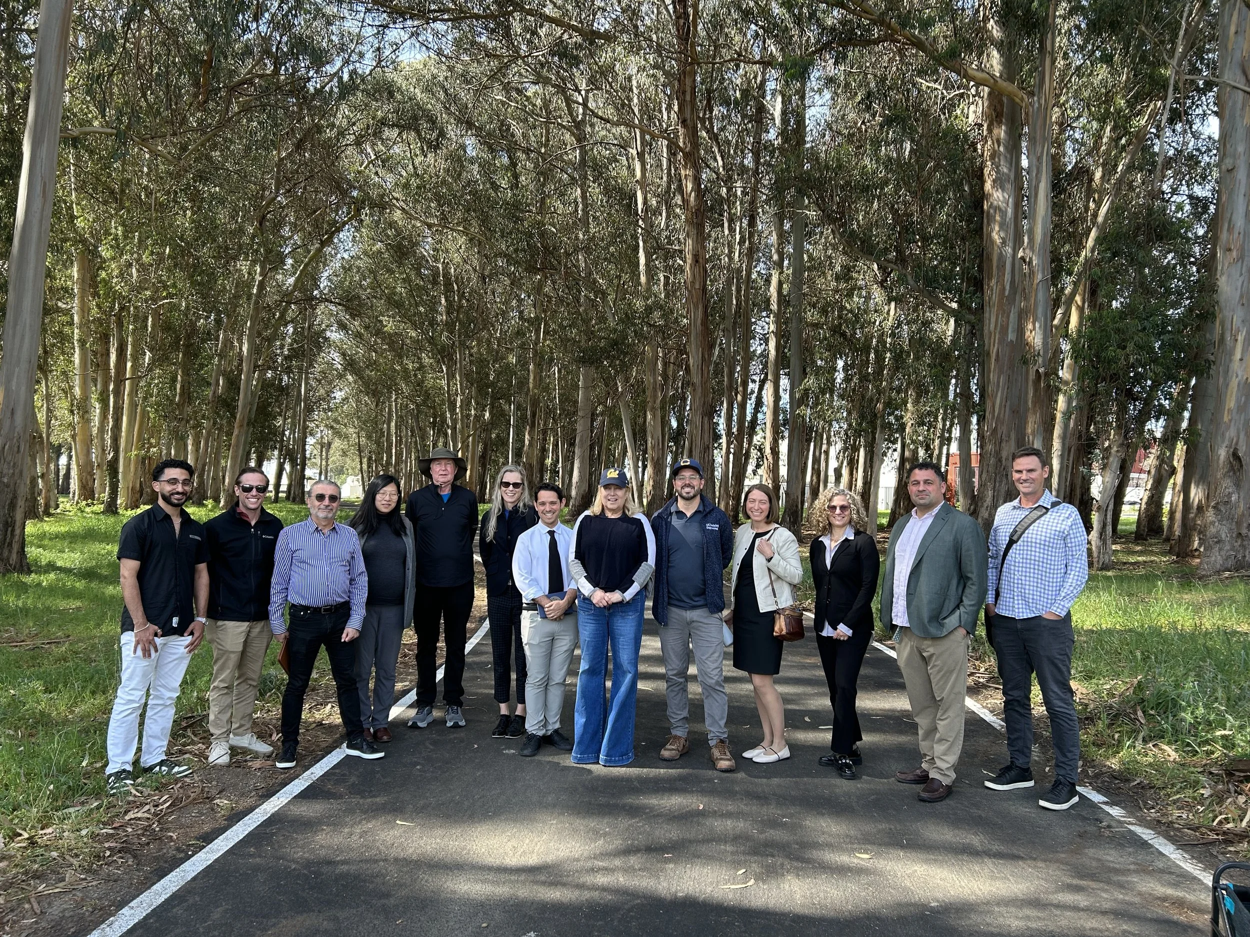 Group shot of Seval Oz's visit in front of a grove of trees