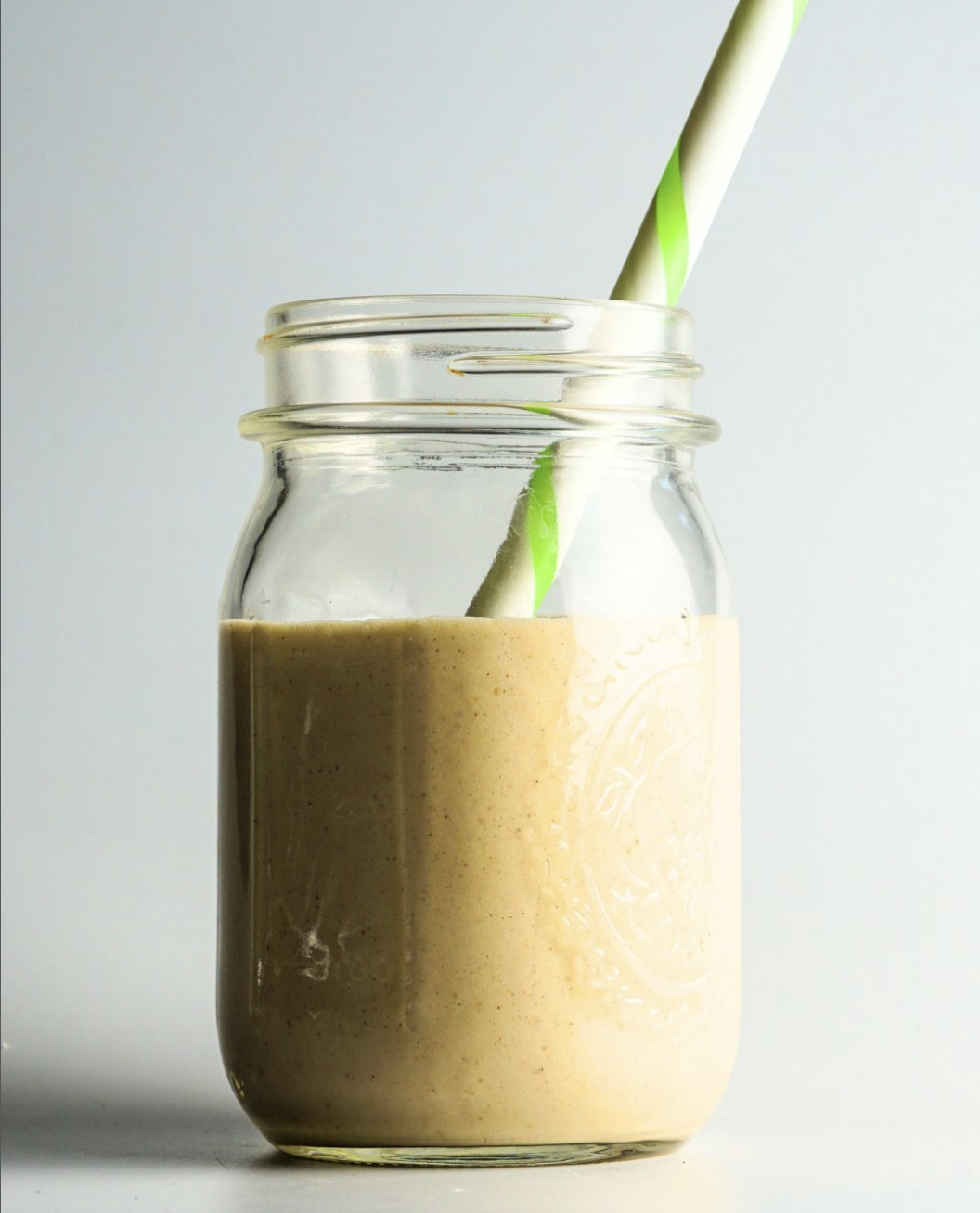 Creamy homemade smoothie served in a glass mason jar