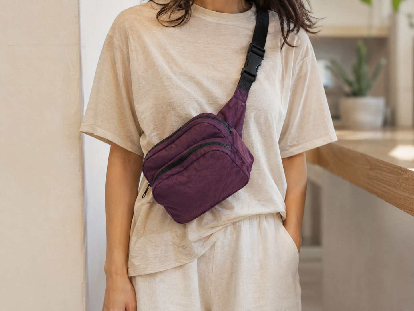 Woman wearing a purple fanny pack crossbody with a casual outfit.