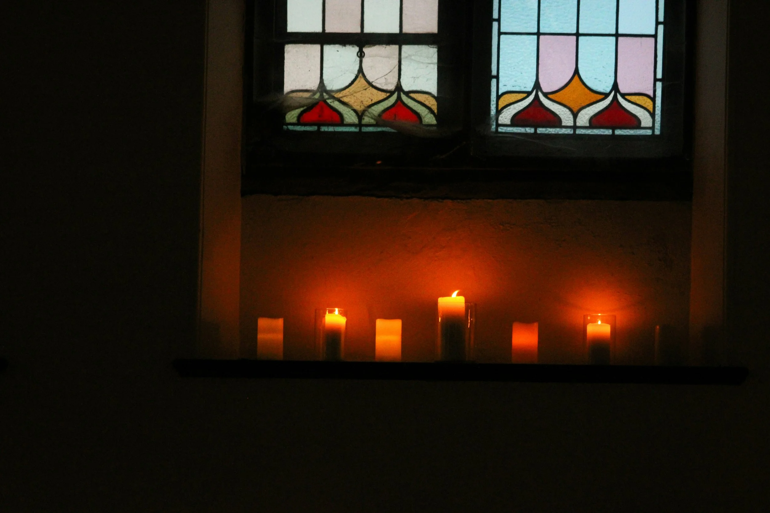 Image of lit candles near stained class windows with text that says: Spiritual friendship group: join us as we explore friendship with God and each other.