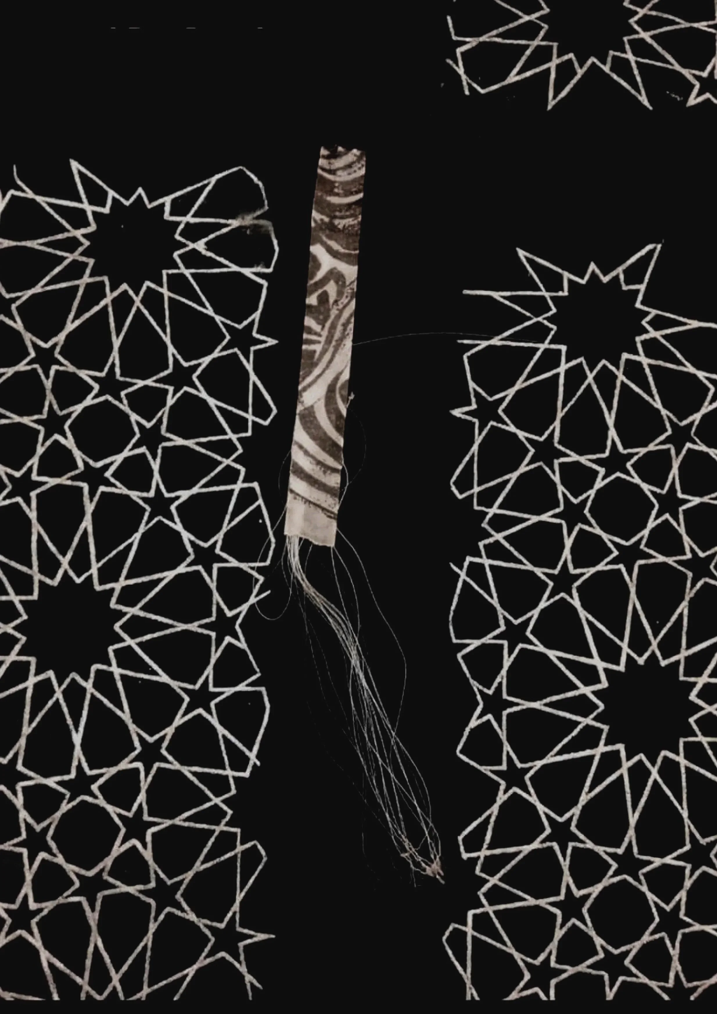 A close-up view of a black fabric with white geometric star and polygon patterns, and a beige and brown patterned cloth with a vertical stripe in the center.