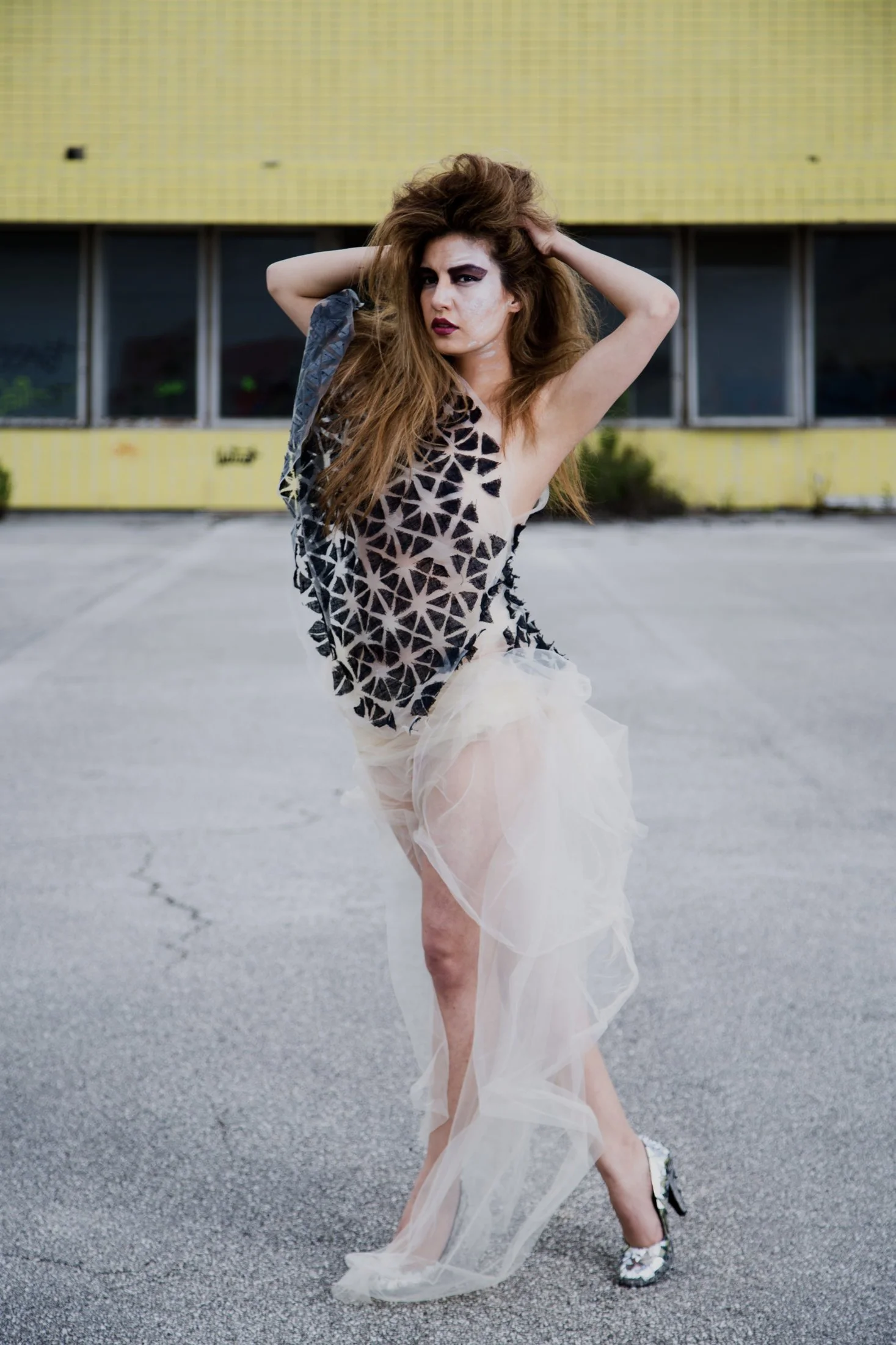 Zara Saberi — Sculptural fashion piece where triangular forms shape the silhouette and the body.