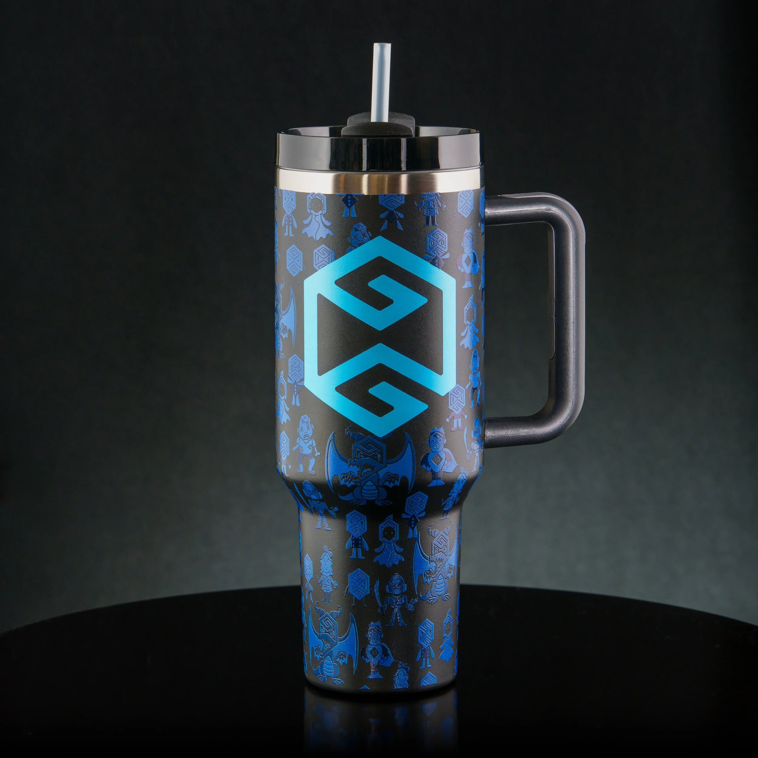 A stainless steel travel mug with a black handle and a lid, decorated with blue cartoon-style characters and geometric patterns, set against a black background.