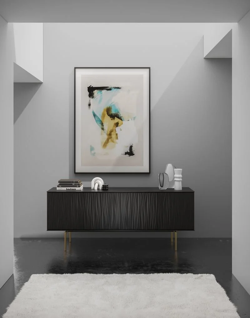 Modern interior hallway with a black sideboard decorated with books and vases, a large abstract art painting on the wall, and a white shag rug on a polished dark floor.