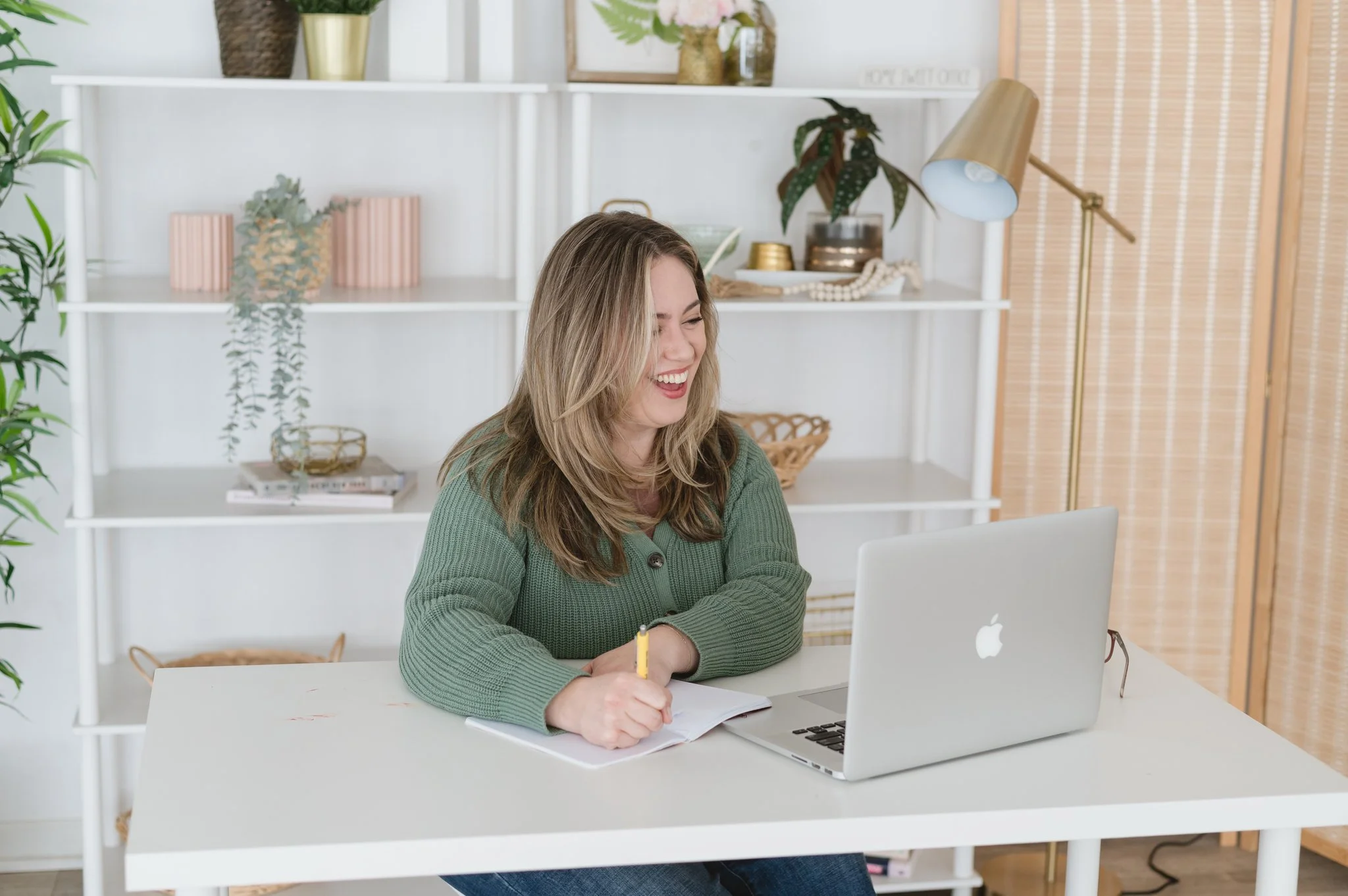 Kim smiling while taking notes at her desk adhd life coach for moms