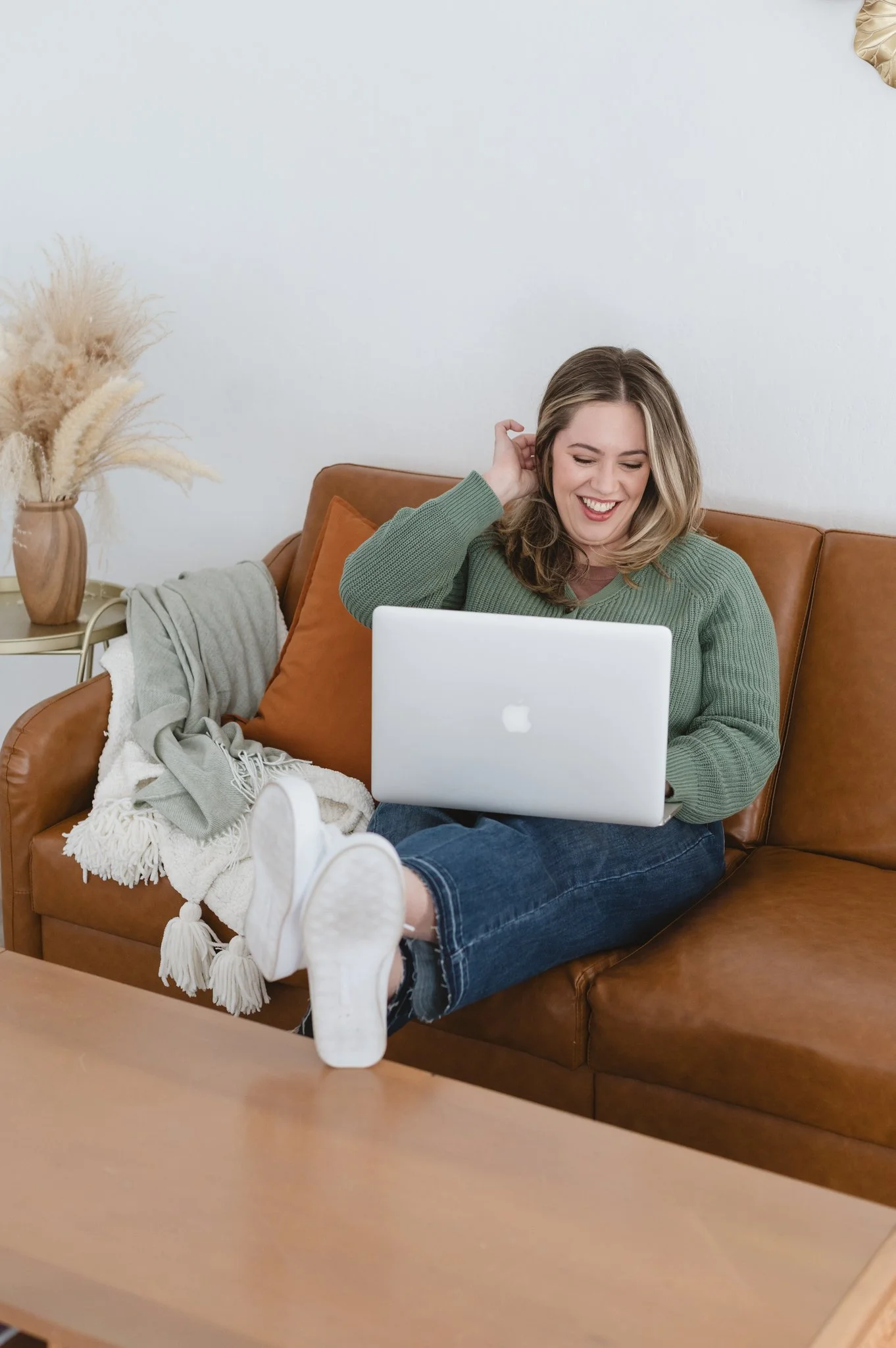 adhd mama life coach Kim relaxing on the couch with her laptop