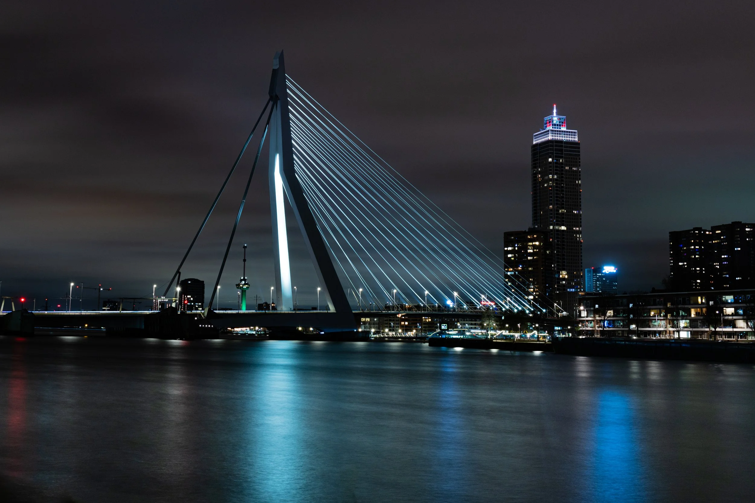 Erasmus Bridge illuminated at night with reflections on river — Rotterdam — Netherlands — by ROEL | WILLEM