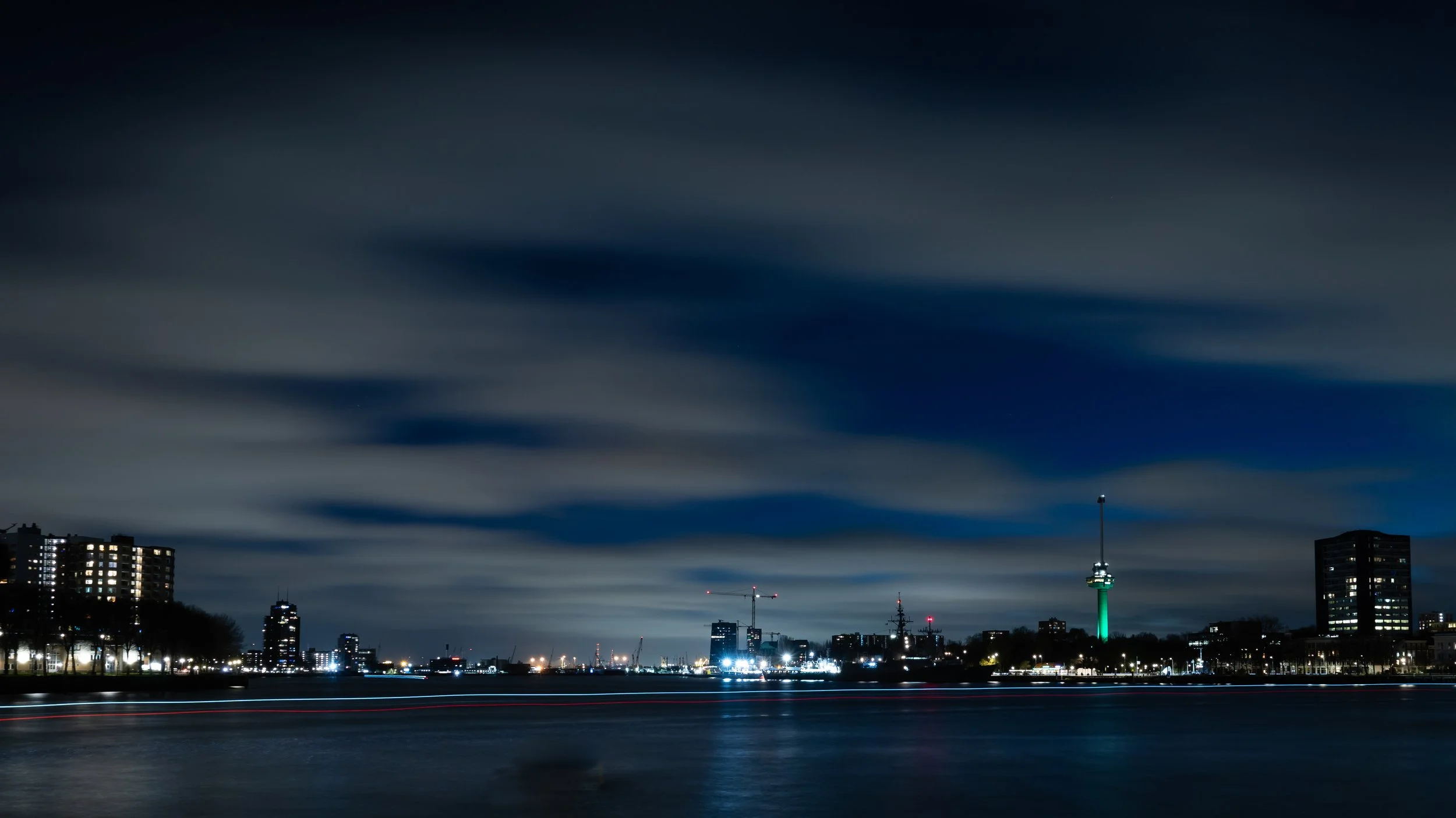 Rotterdam skyline with Euromast visible across river at night — Netherlands — by ROEL | WILLEM