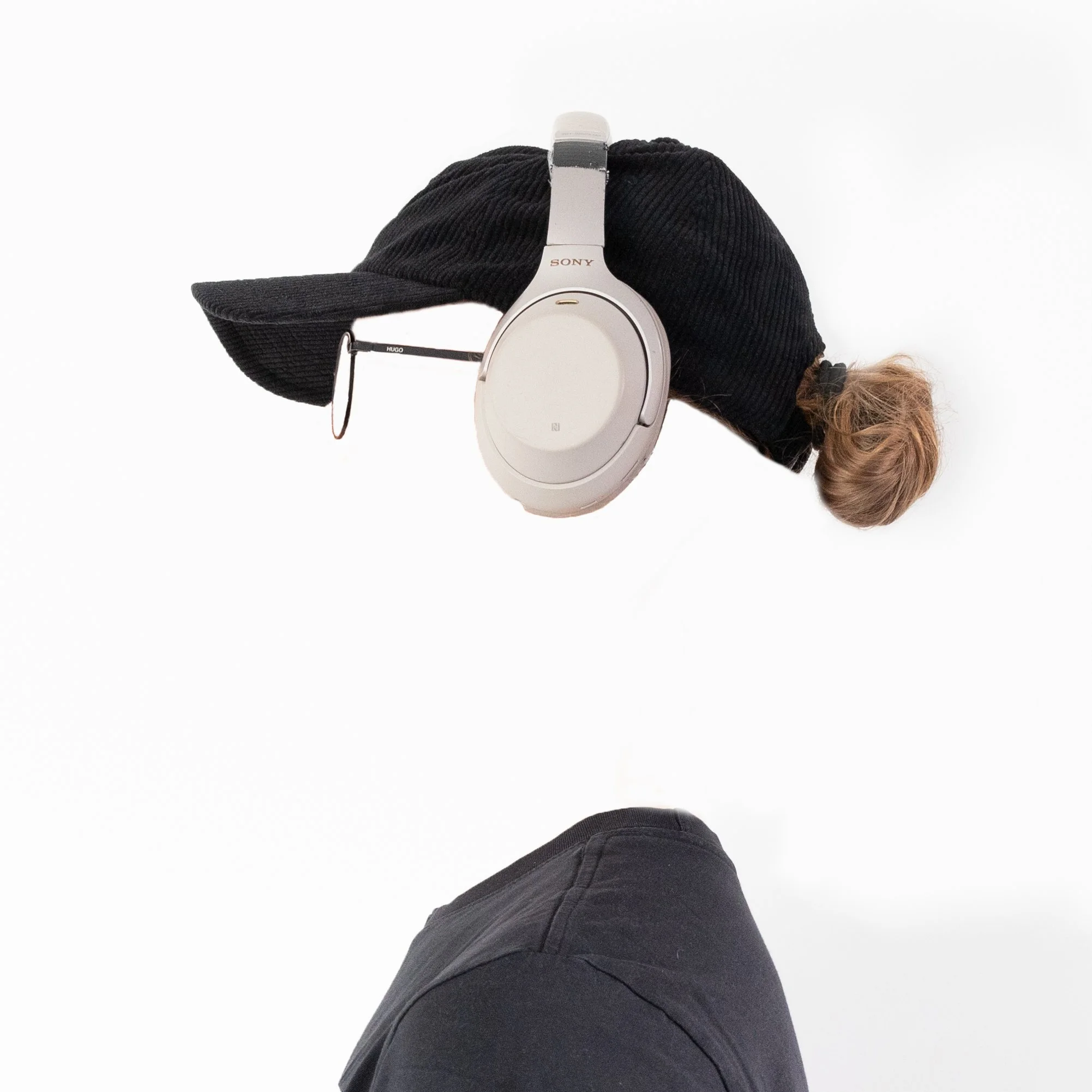 Invisible person wearing cap and white headphones without visible face — by ROEL | WILLEM