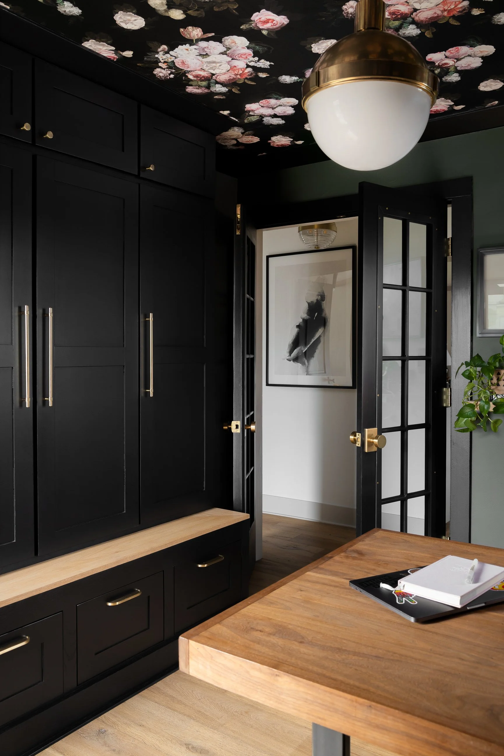 Drop station with black cabinetry and floral wallpaper on the ceiling