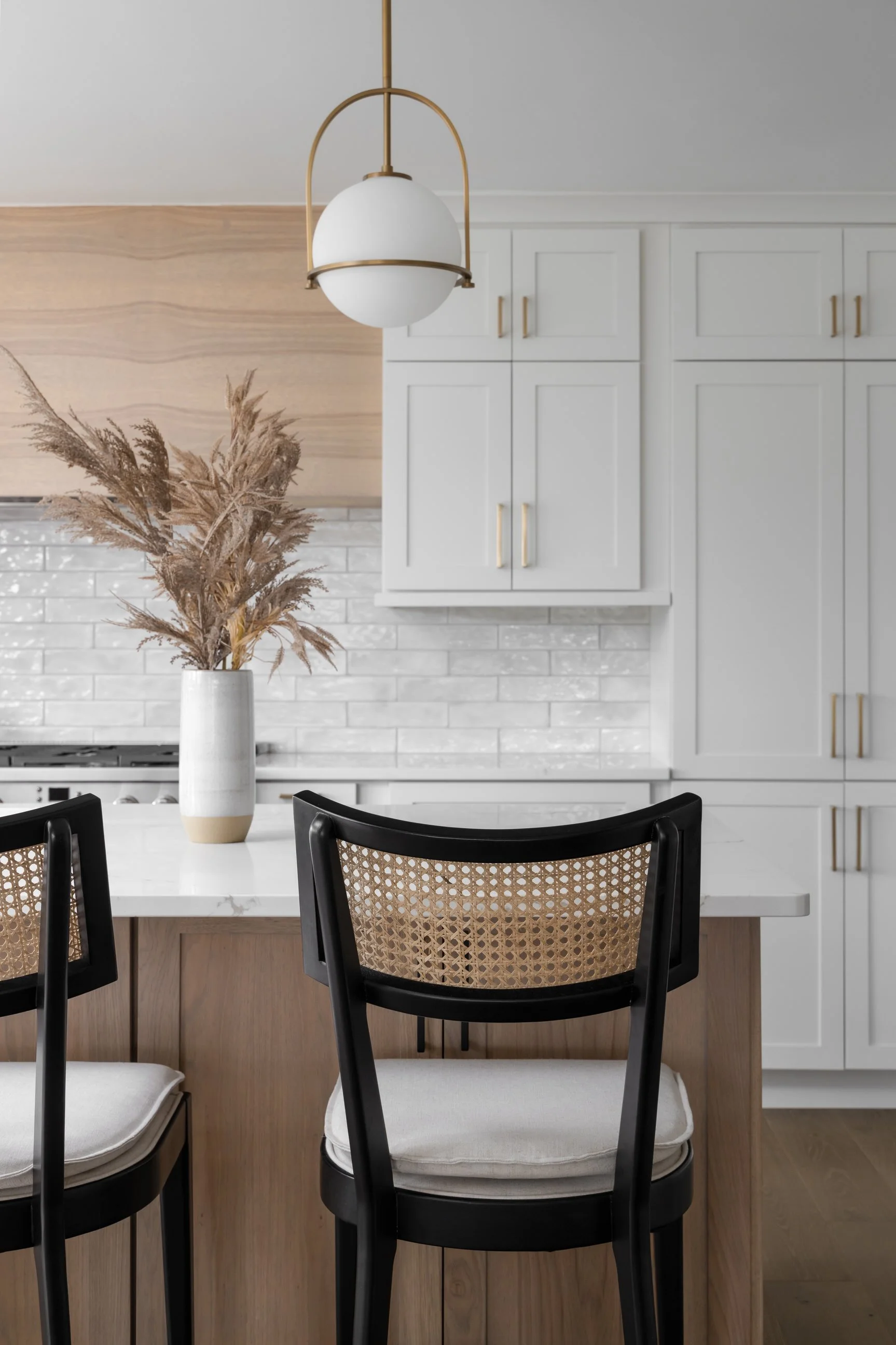 Kitchen island with dark black stools against white cabinetry 