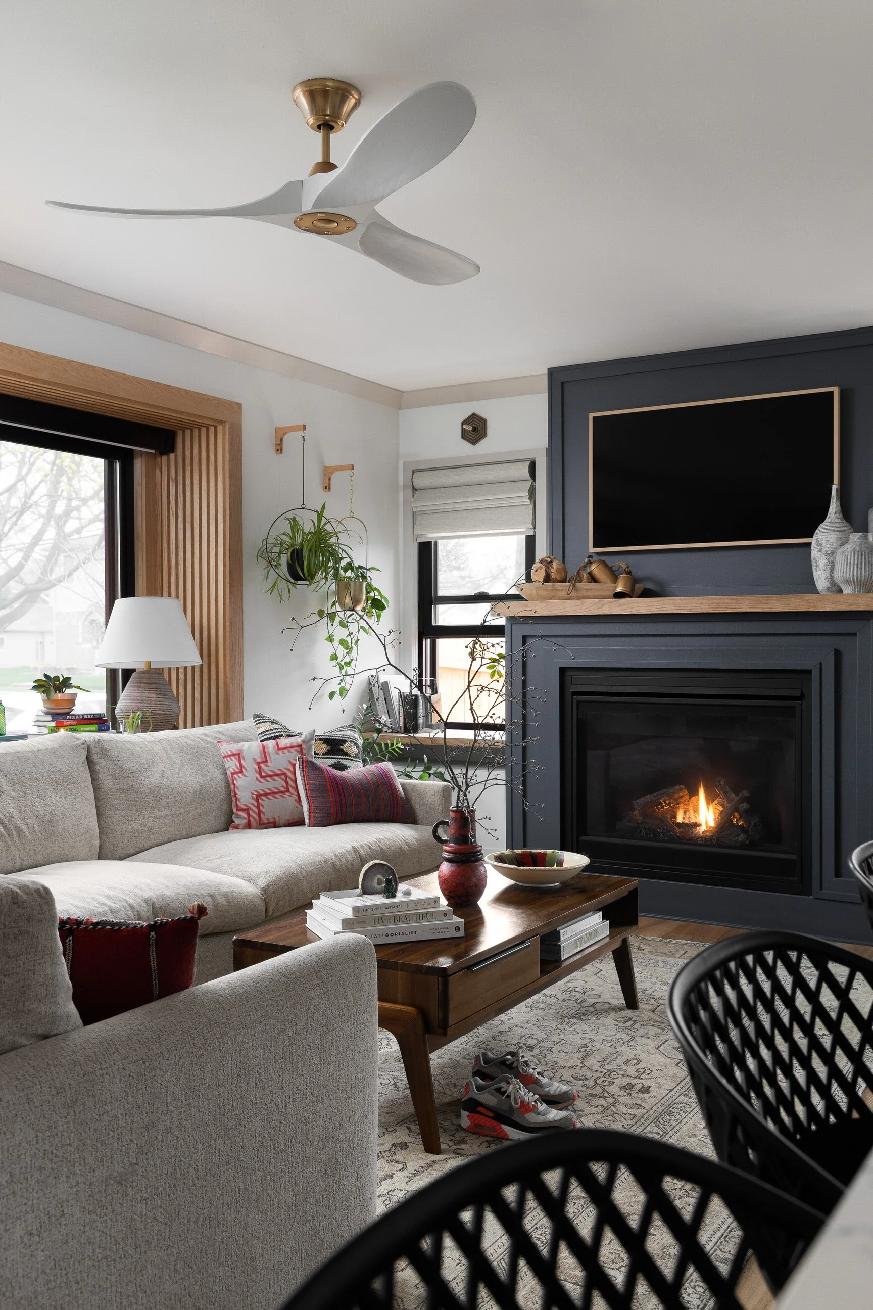Transitional living space with dark fireplace and gray sofa
