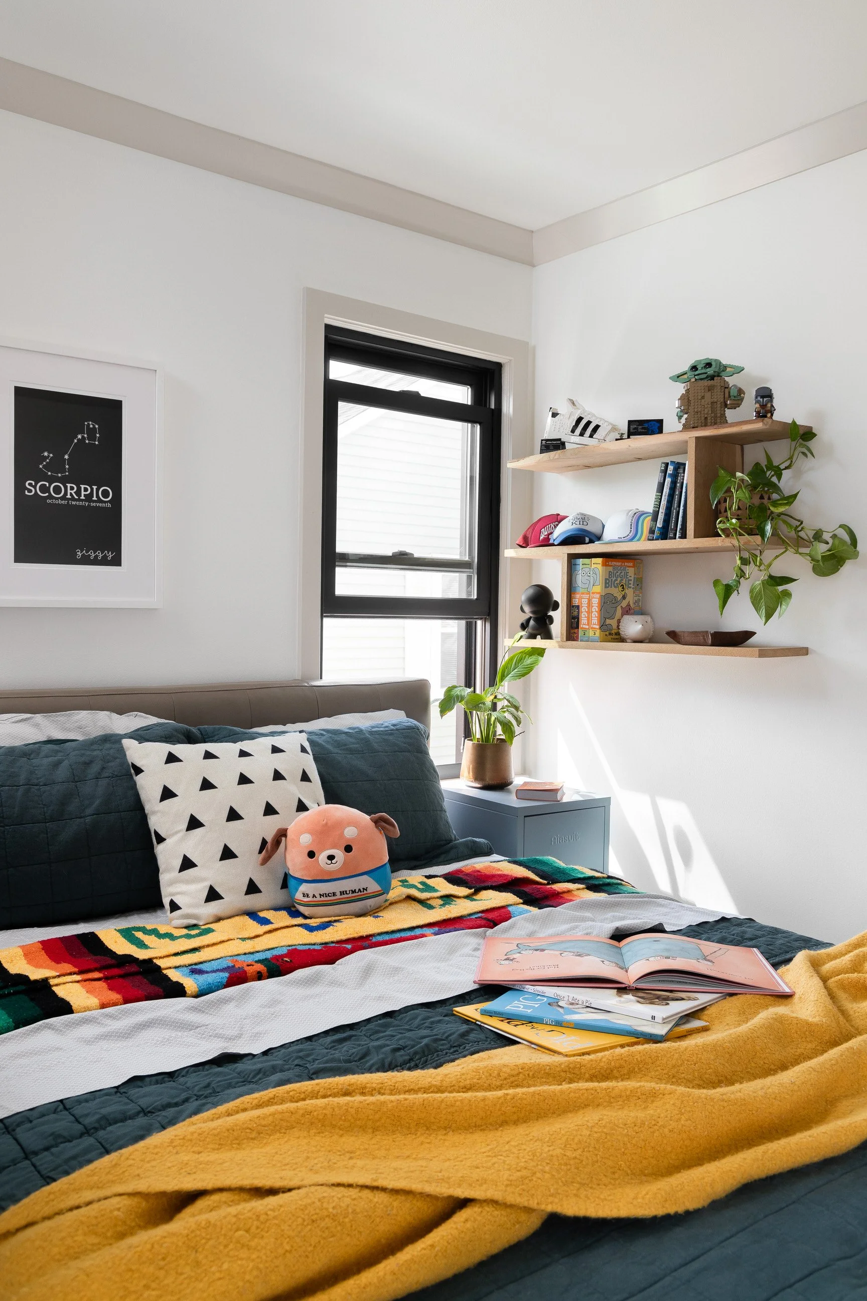 Layered and lived in bedroom with mustard yellow blanket, floating shelves and fun pillows