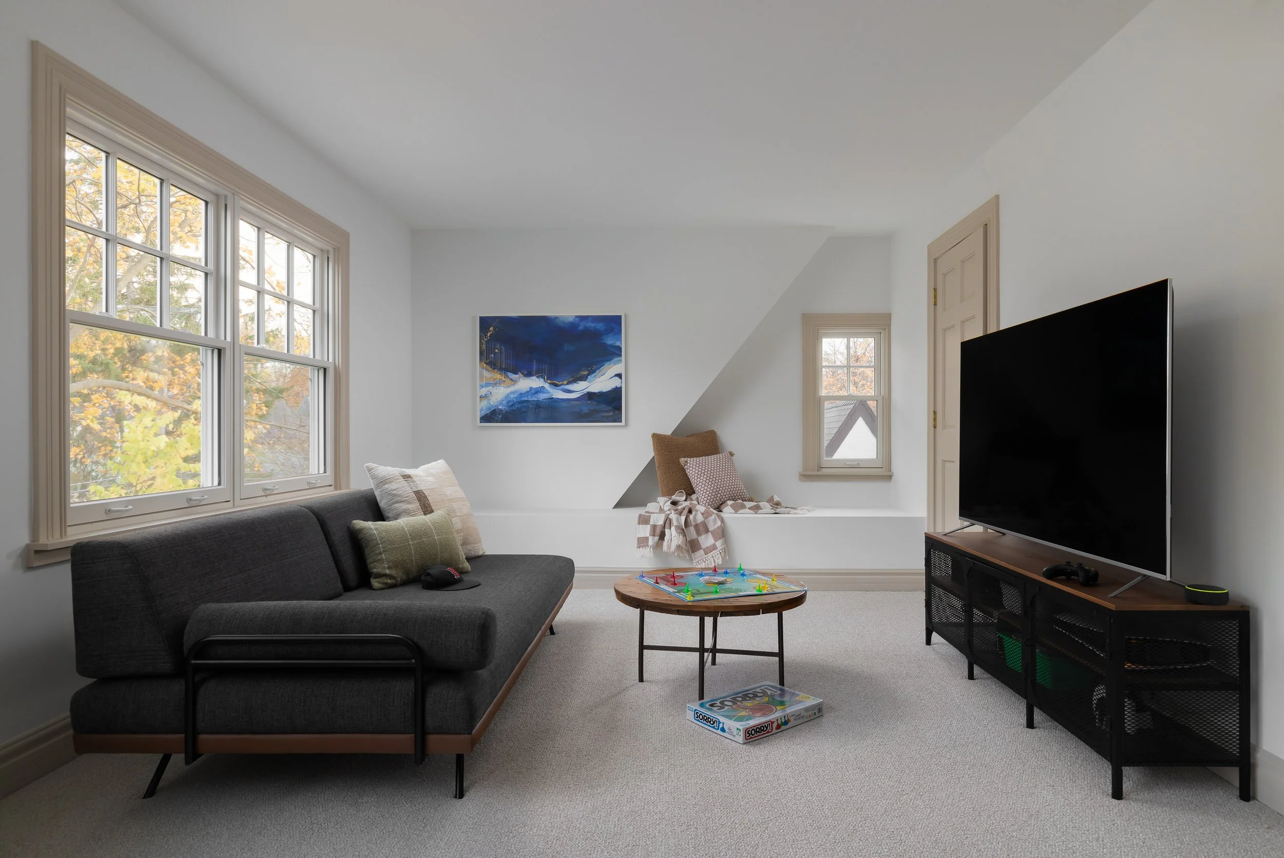 Living space with dark sofa, wall art and TV