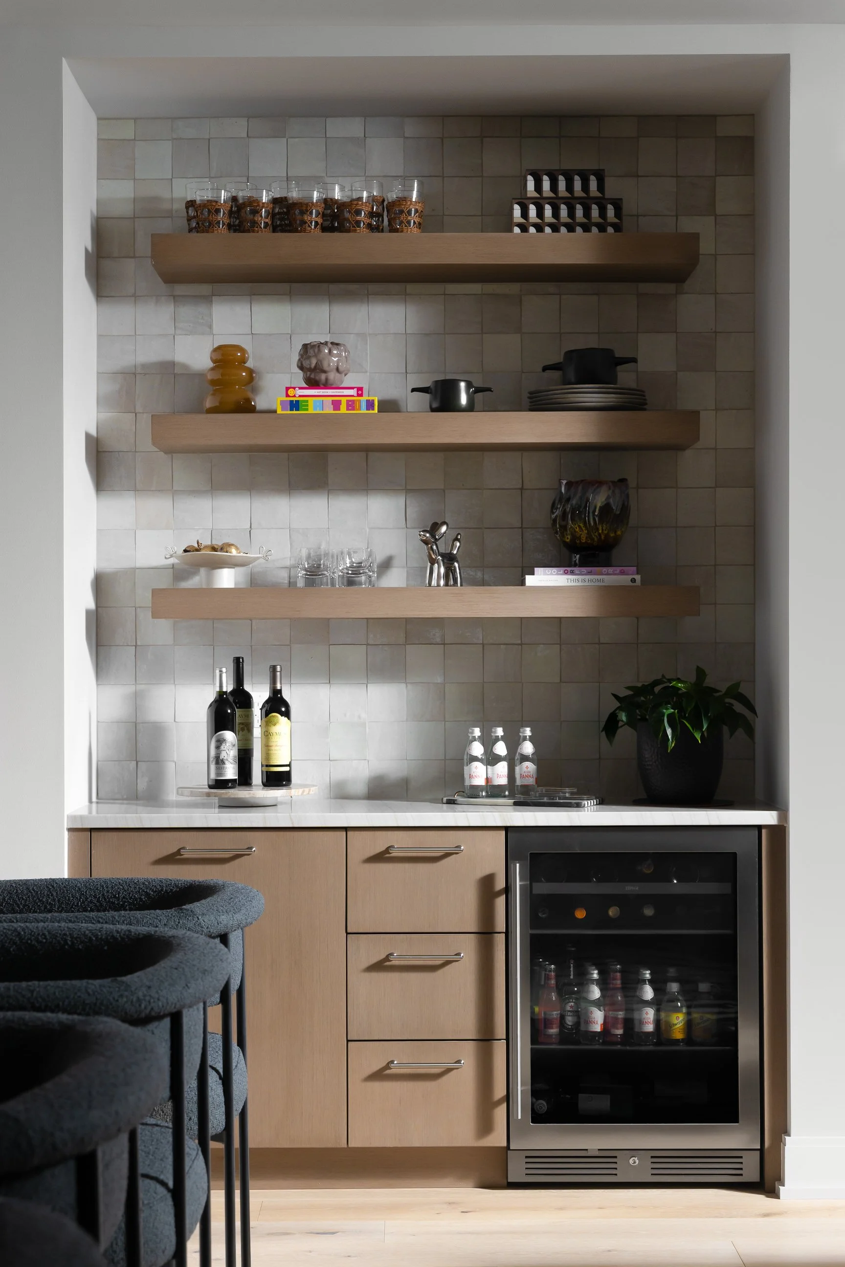 Modern and clean wet bar design with wine fridge and floating shelves