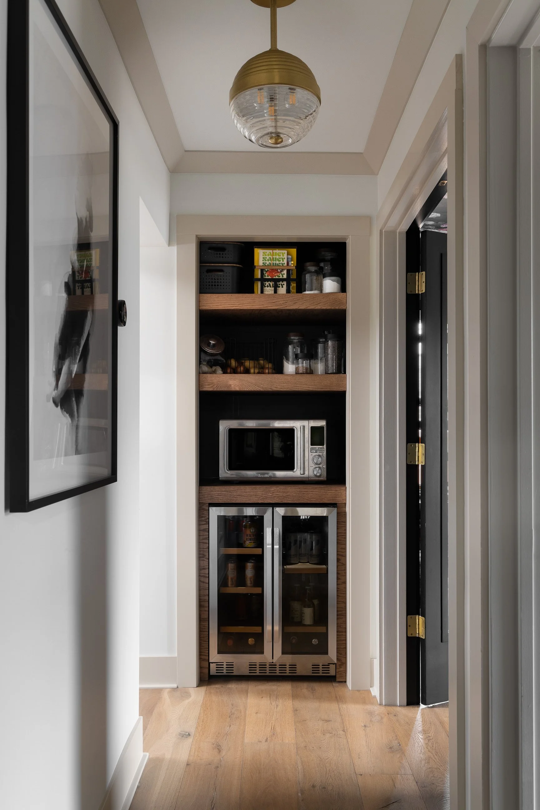 Hallways with trimwork, beautiful light and wine fridge