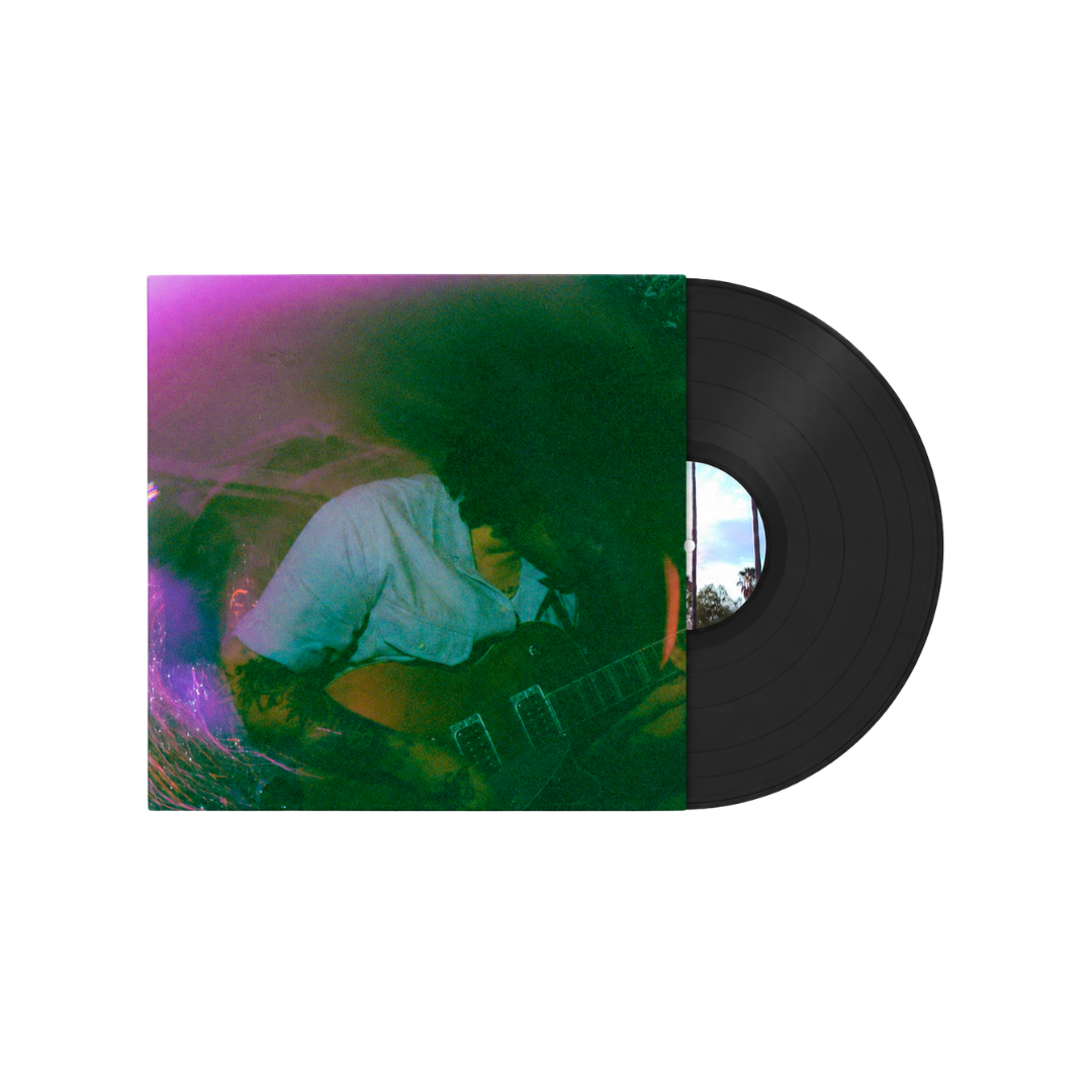 Cover art for Los Angeles based psych punk band Babe Ruthless' LP 'I Hate Babe Ruthless.' Photo is blurry and features frontman Mark Martino playing electric guitar in a colorful, dimly lit room.