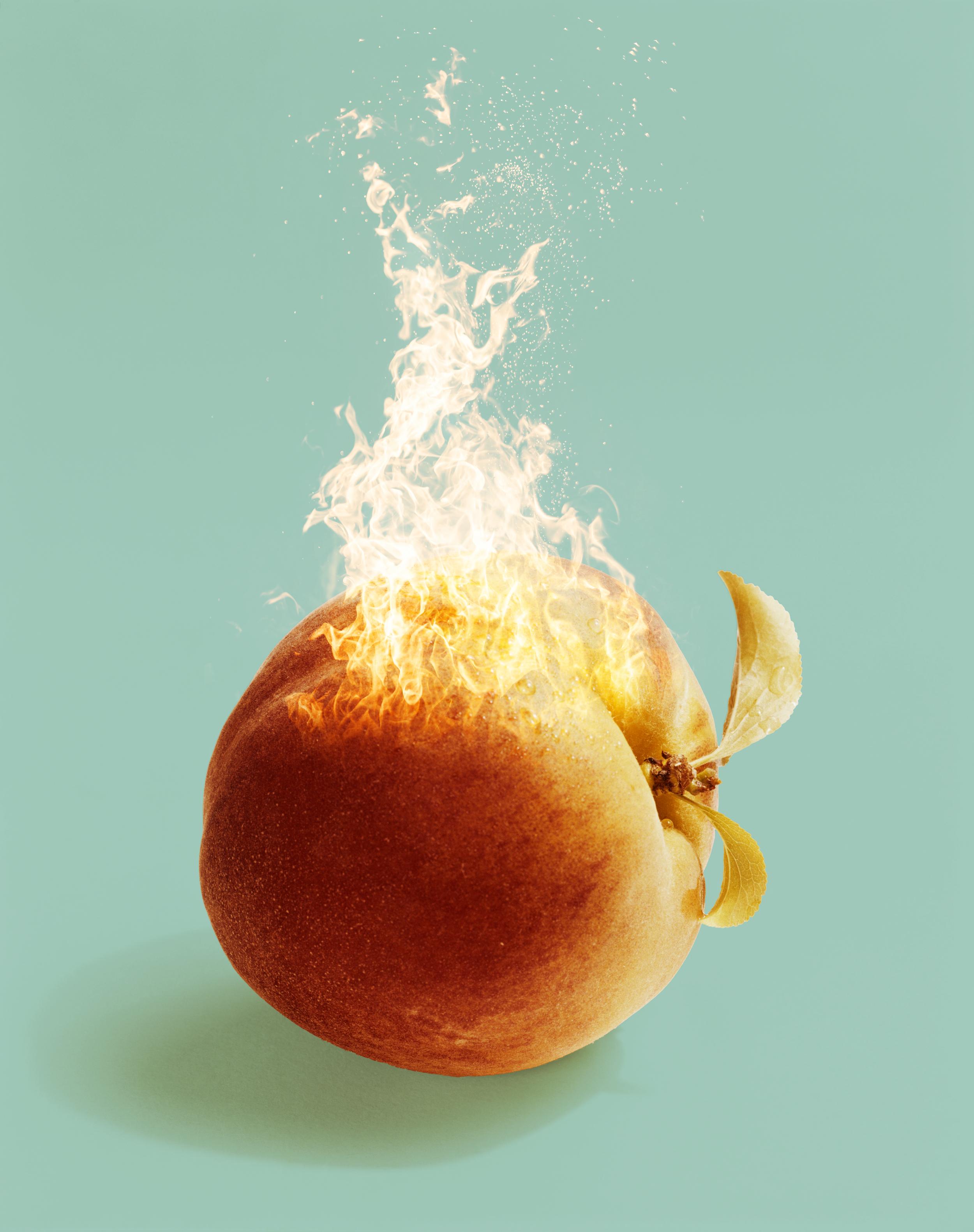 A peach with flames and sparks coming out of its top, set against a mint green background.
