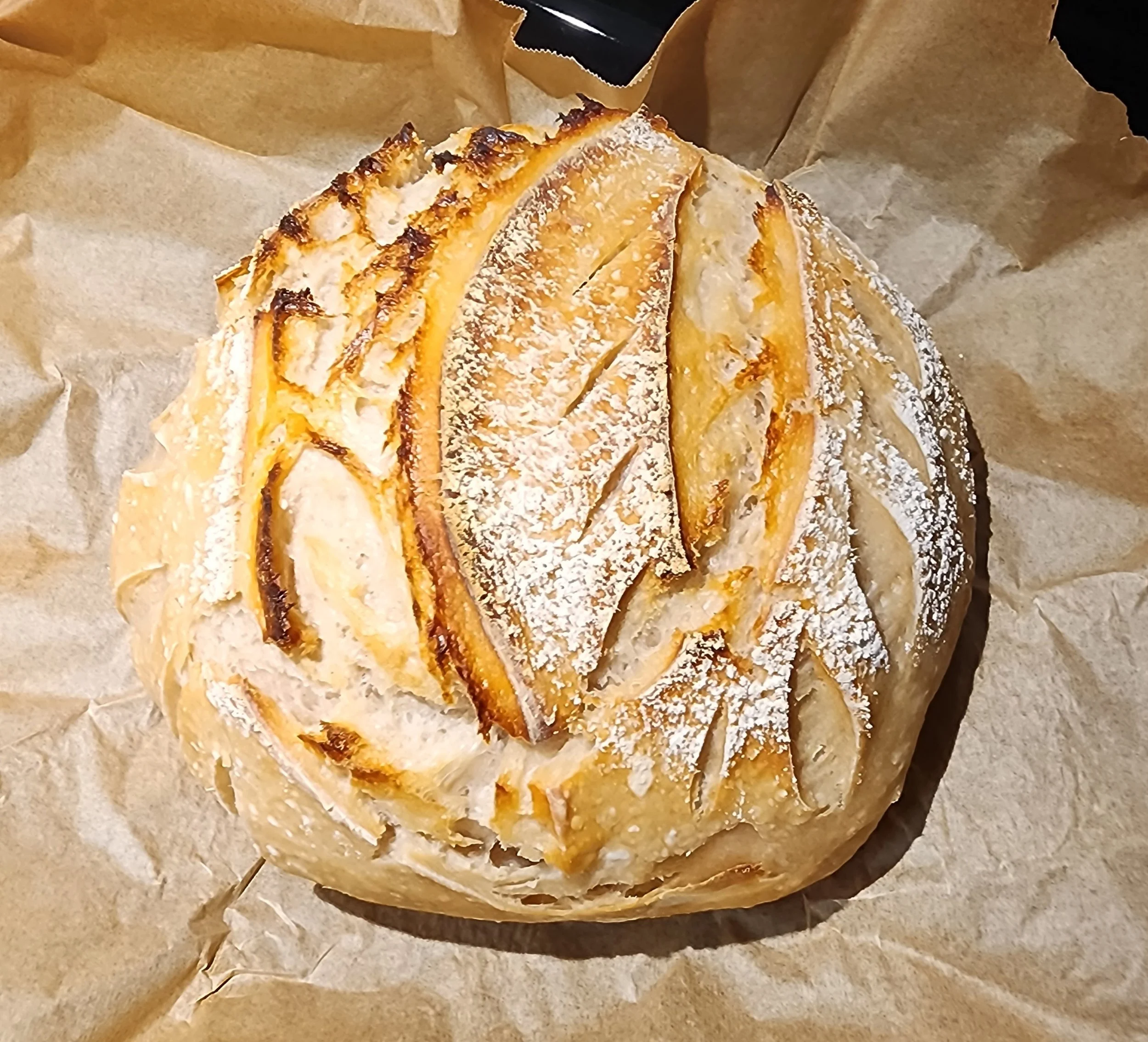 A partially eaten piece of a layered cake with golden filling and toasted white frosting, resting on parchment paper.