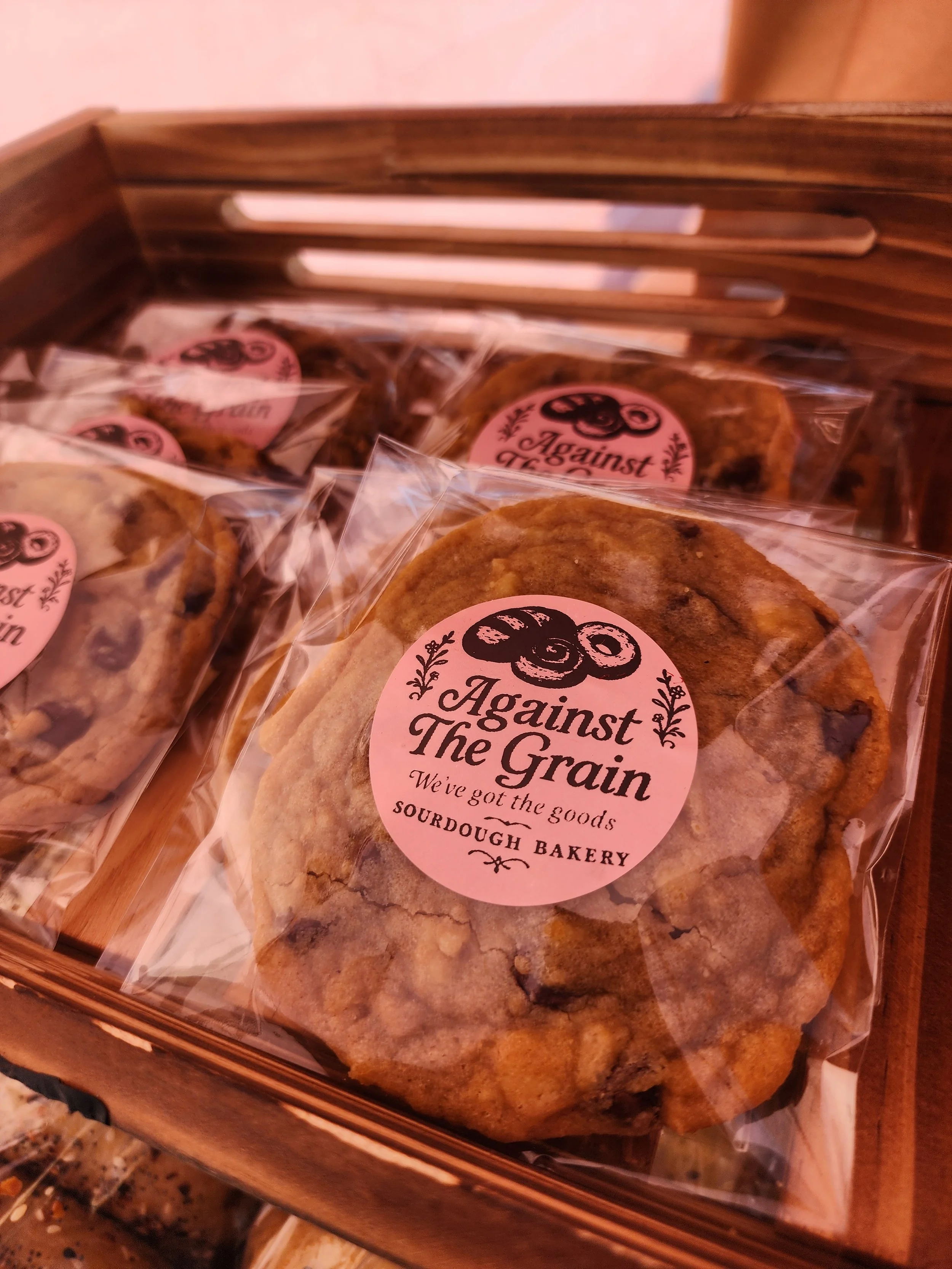Bakery box containing scone and individually wrapped cookies, labeled "Against The Grain" from Sour Dough Bakery.