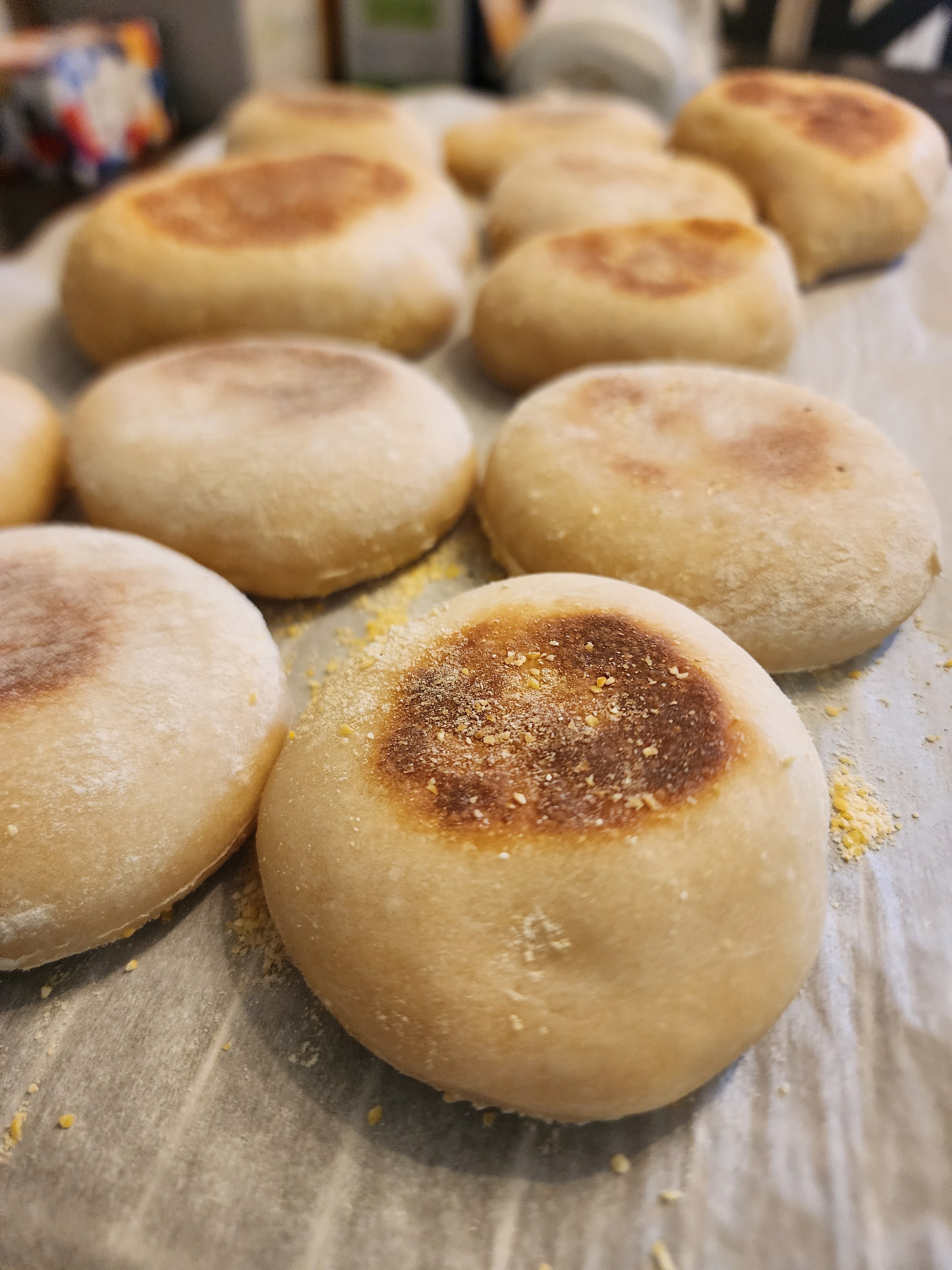 Close-up of freshly baked bread rolls with golden-brown tops on a baking sheet.