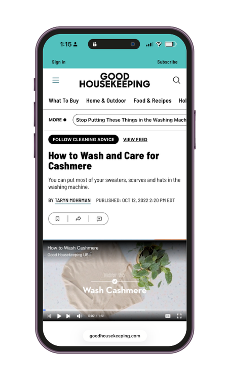A smartphone displaying a webpage from Good Housekeeping about washing and caring for cashmere. The article title is "How to Wash and Care for Cashmere," with a thumbnail video titled "Wash Cashmere."