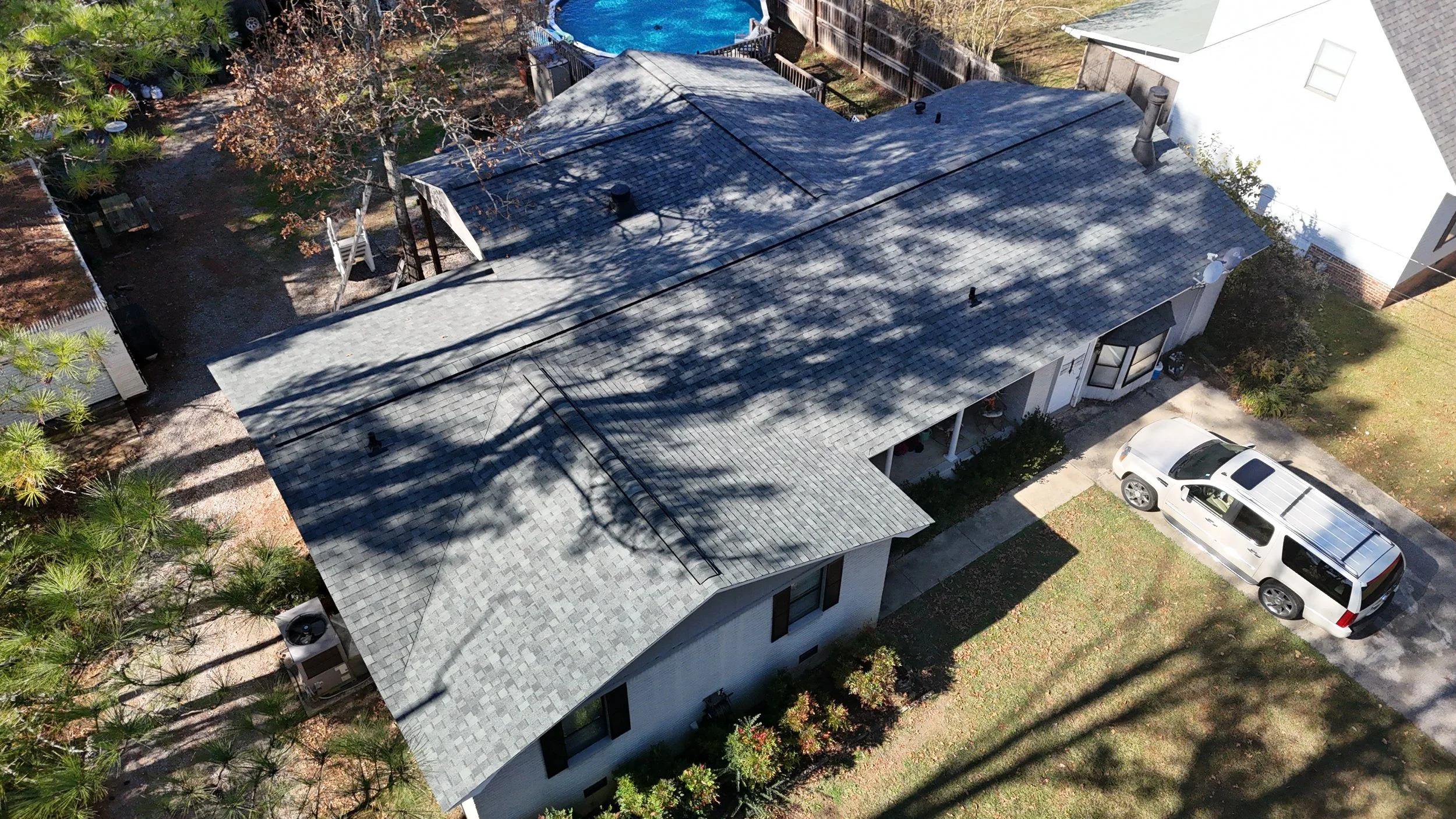 An aerial view of a house with a gray shingle roof that Revolution Roofing installed on this home in the fall. 