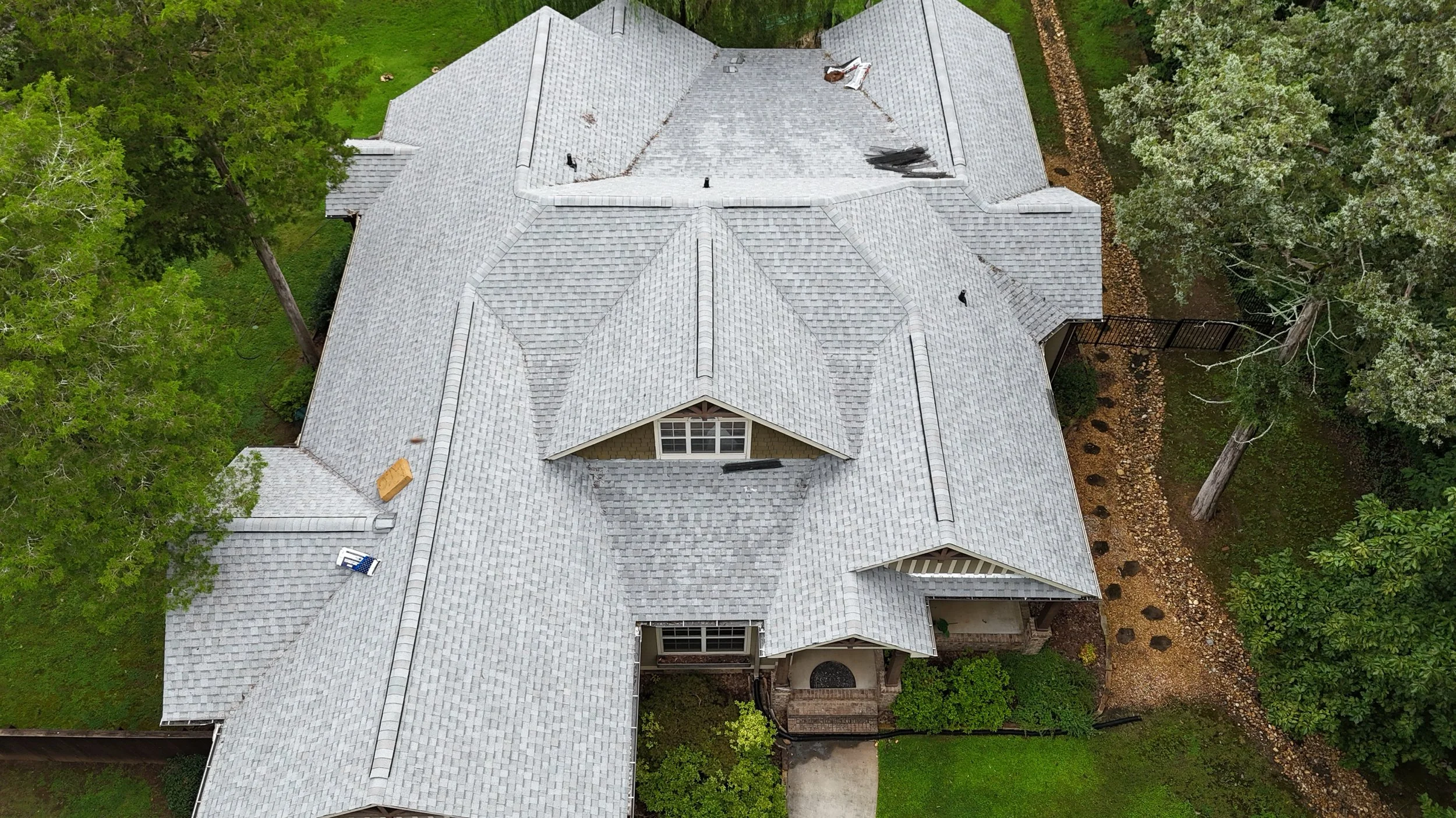 Aerial view of a house with a gray & white shingle roof that Revolution Roofing installed for the homeowners. 