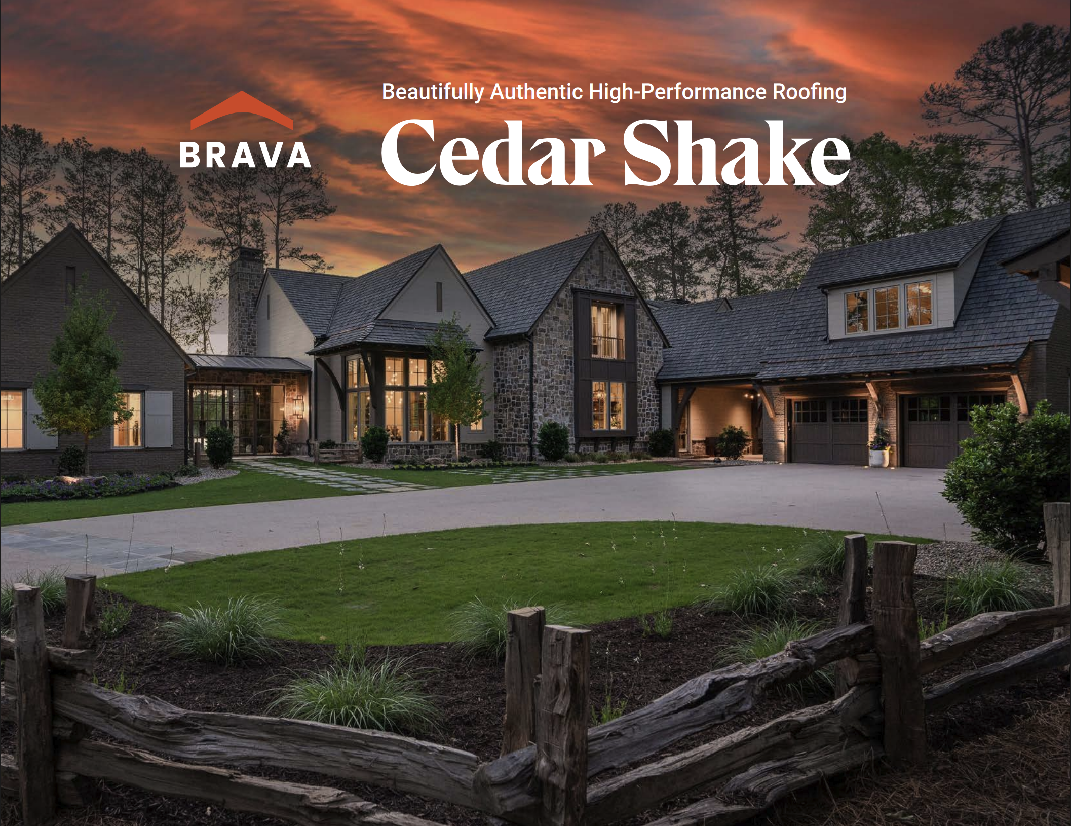 A modern multi-story house with stone and siding exterior, large windows, and a landscaped yard at sunset with a colorful sky.