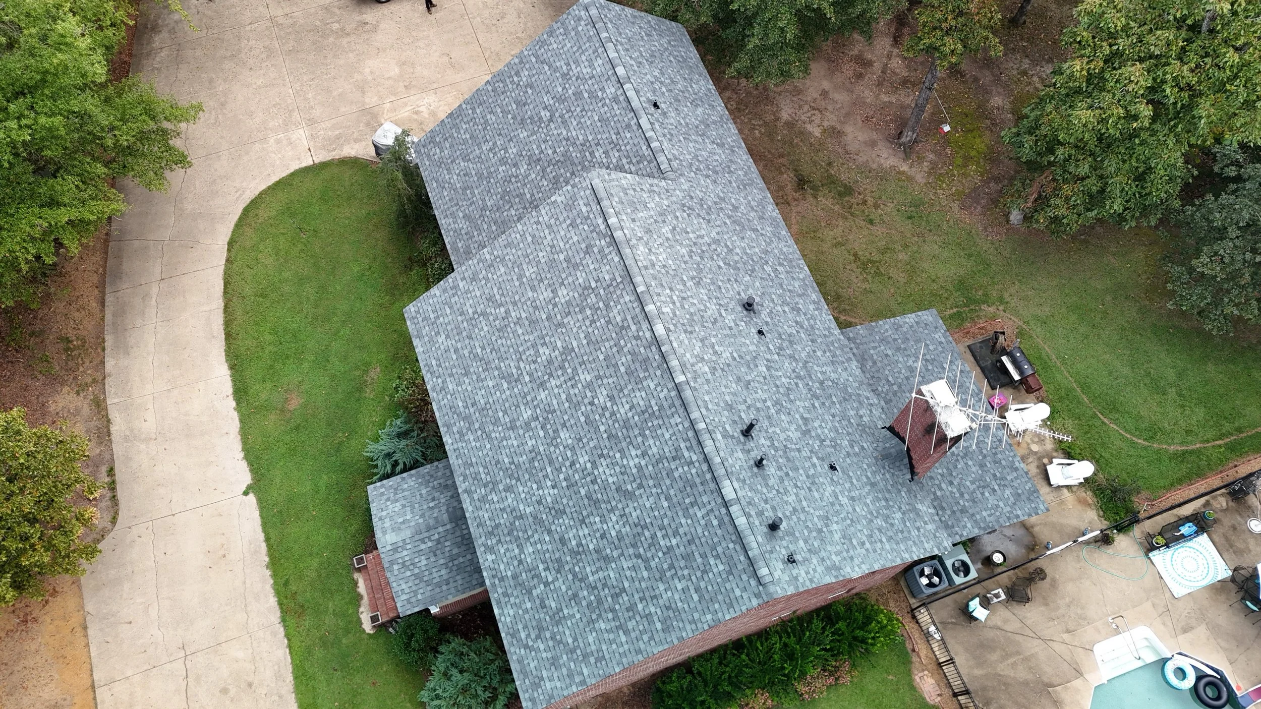 An aerial view of a house with a beautiful gray shingles roof that Revolution Roofing installed. 