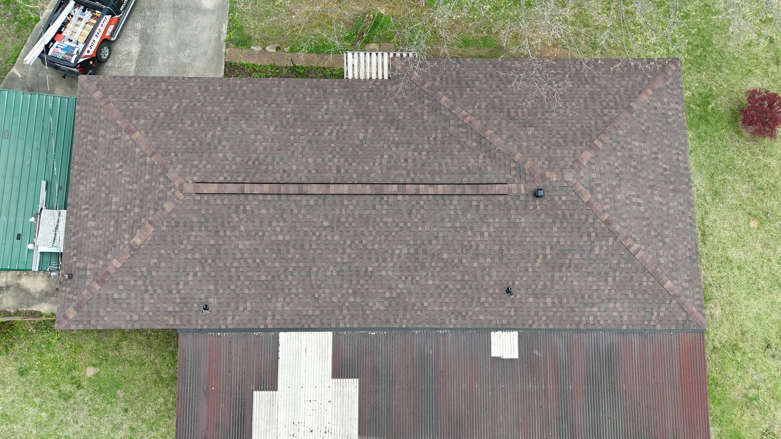 Aerial view of a house roof with brown shingles that Revolution Roofing installed on this home