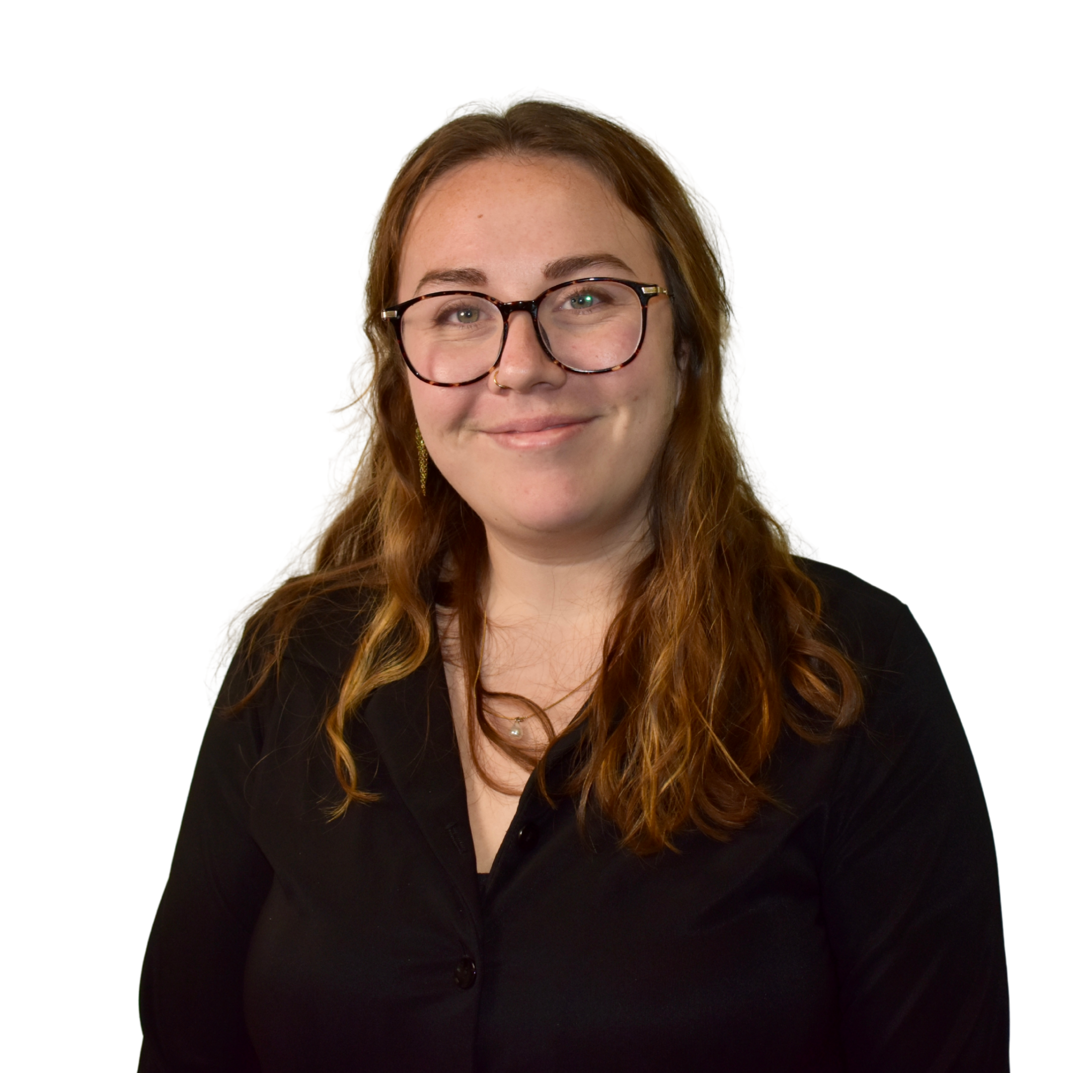 A woman with light brown, wavy hair wearing glasses with a tortoiseshell pattern, smiling at the camera, dressed in a black blazer.