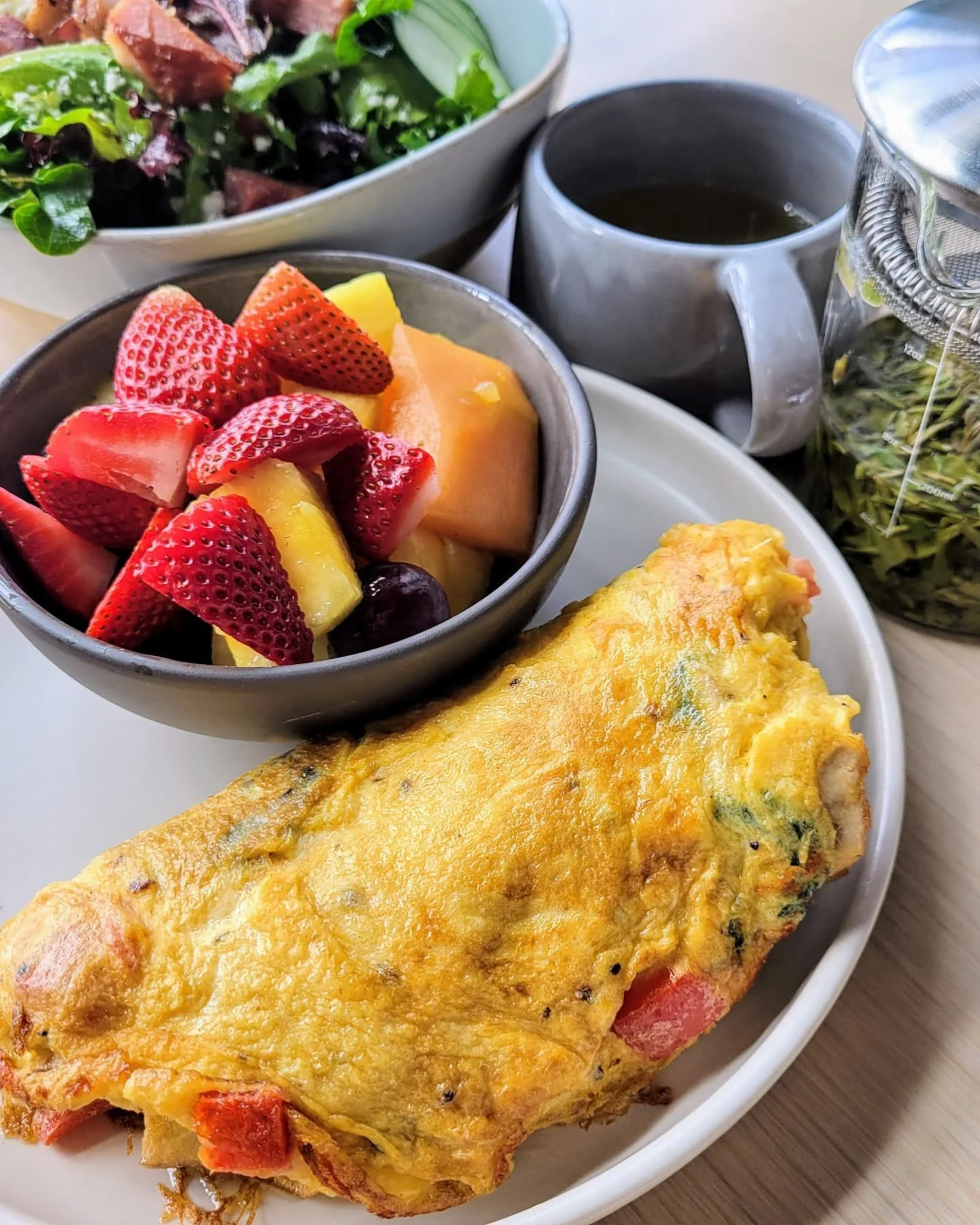 Golden, fluffy omelette paired with a vibrant mix of fresh, seasonal fruit