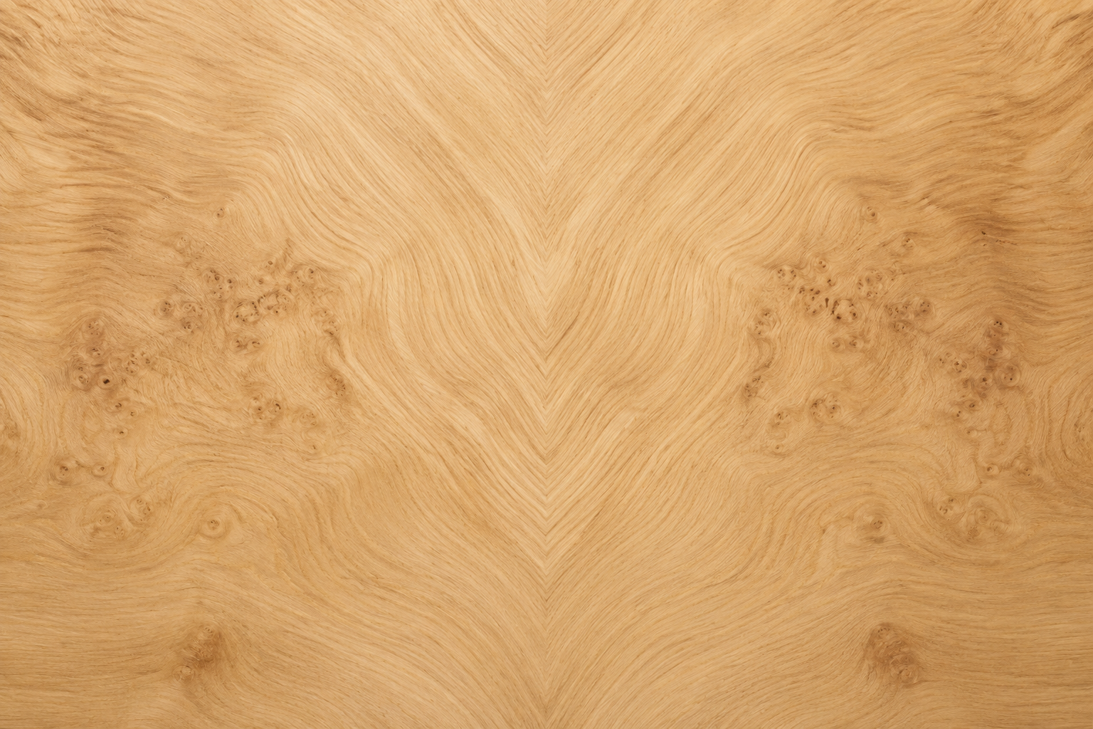 Close-up of a light-colored wooden surface with natural grain patterns and knots.