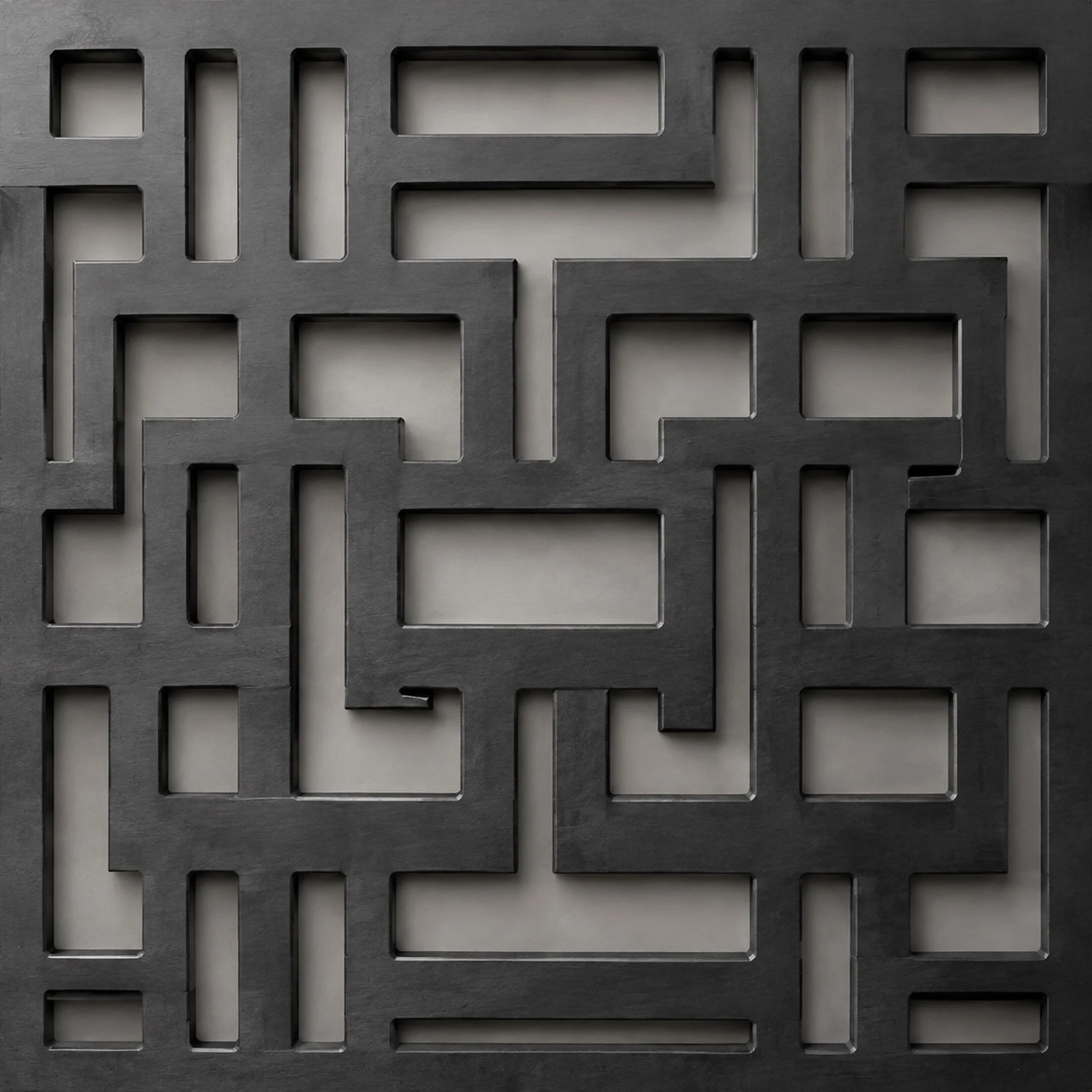 Close-up of a matte black steel panel with a precise geometric CNC-cut pattern.