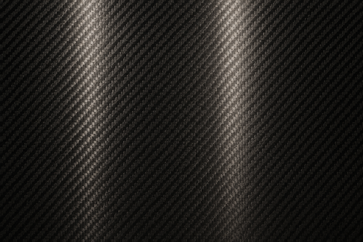 Close-up of a black carbon fiber surface with a textured, woven pattern