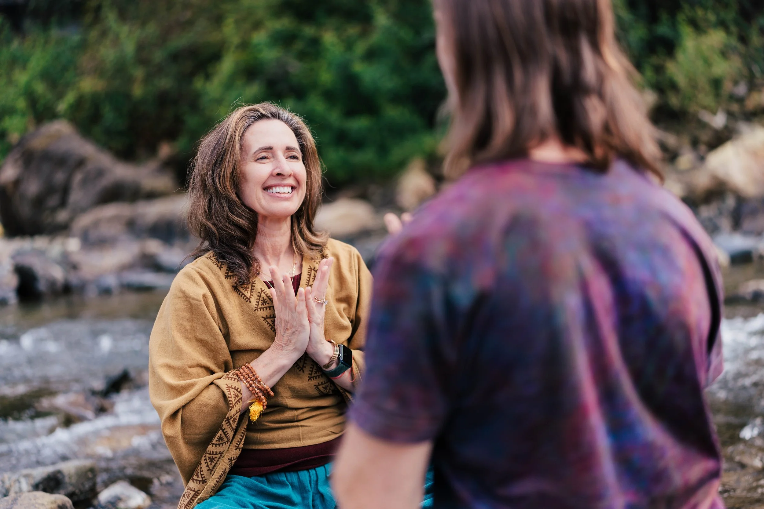Lexie smiling and talking to Bill, with her hands in Anjali Mudra.