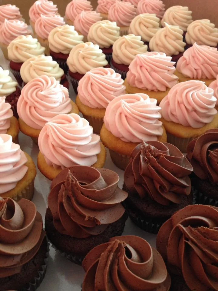 Assorted cupcakes with pink and chocolate frosting.
