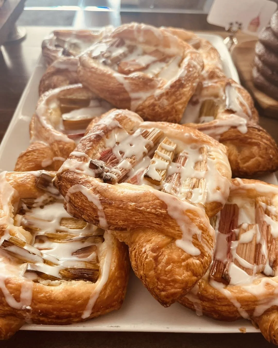 A platter of cinnamon rolls topped with icing and chopped pecans.