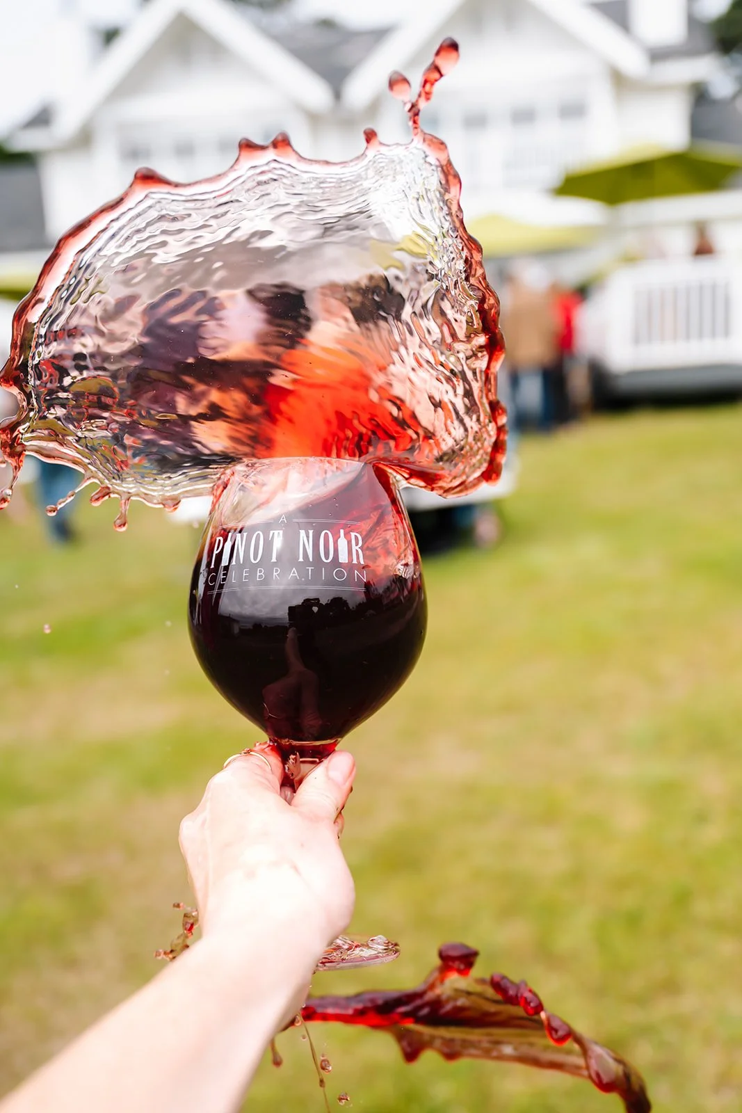 Pinot Noir Glass with wine splashing out of the glass at Winesong Wine Festival in Mendocino and Fort Bragg, California